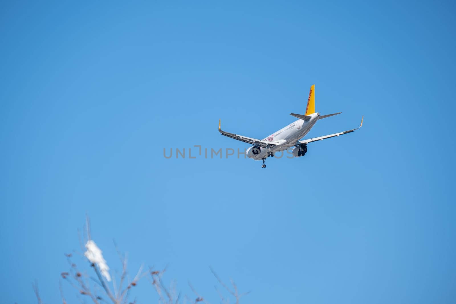 Commercial airplane flying high in clear blue sky