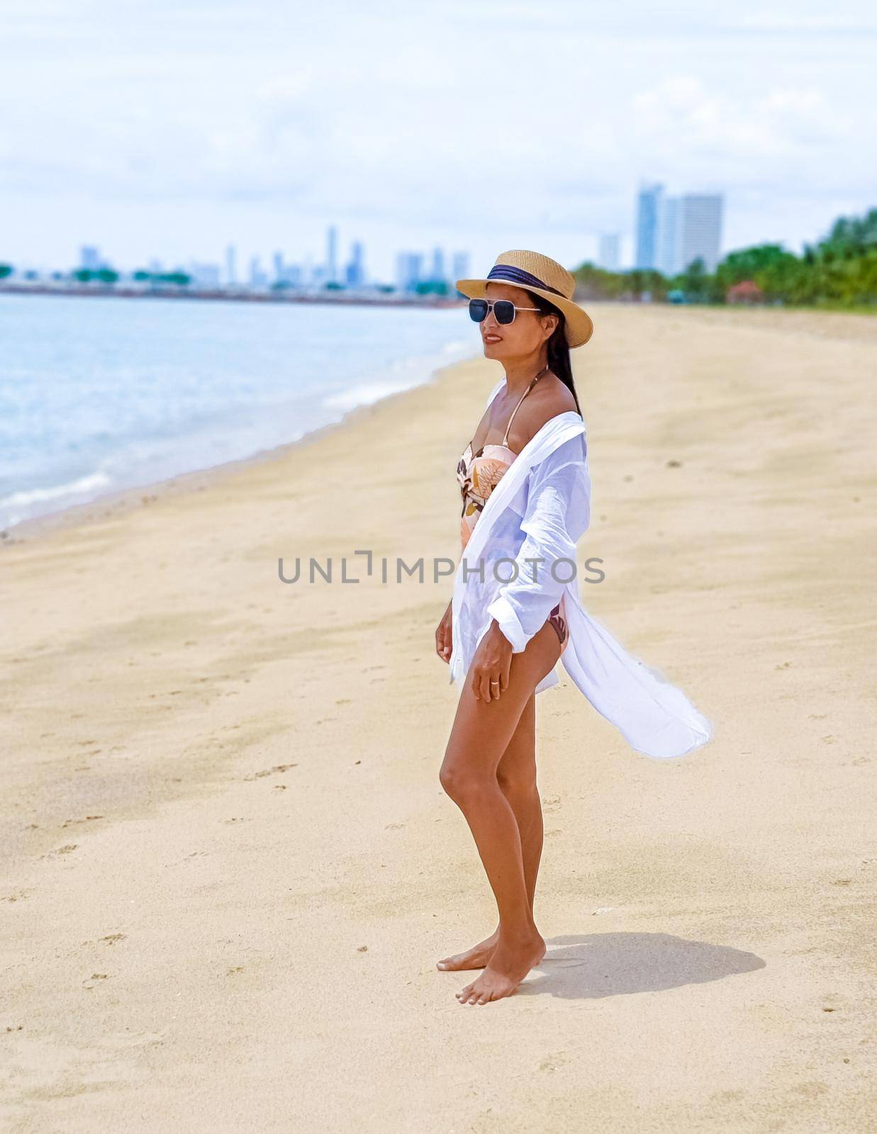 Women relaxing on a beach chair sunny day with hammock on beach in Pattaya Thailand Ban Amphur beach by fokkebok