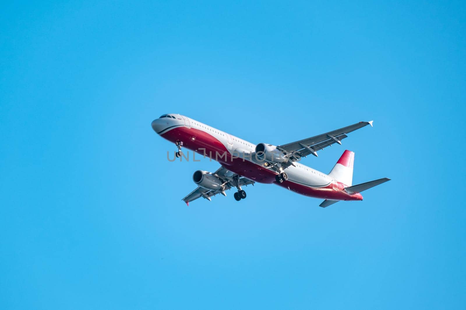 Commercial airplane flying high in clear blue sky