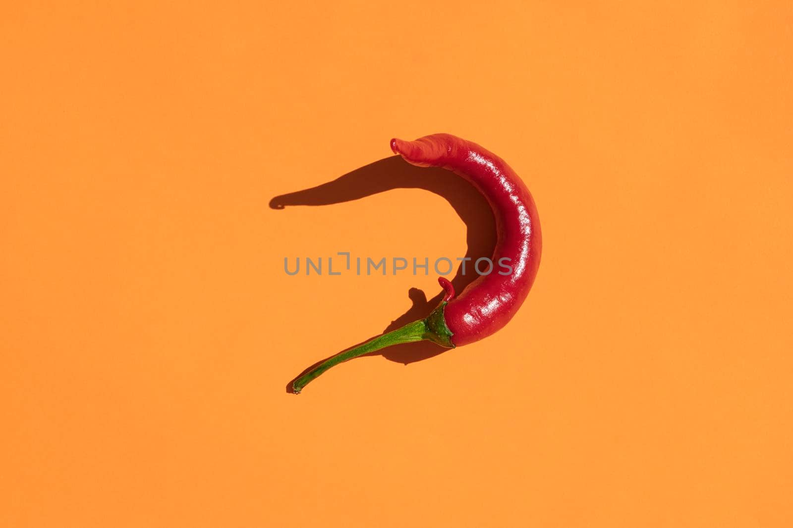 red hot pepper on a yellow background with a hard shadow. High quality photo