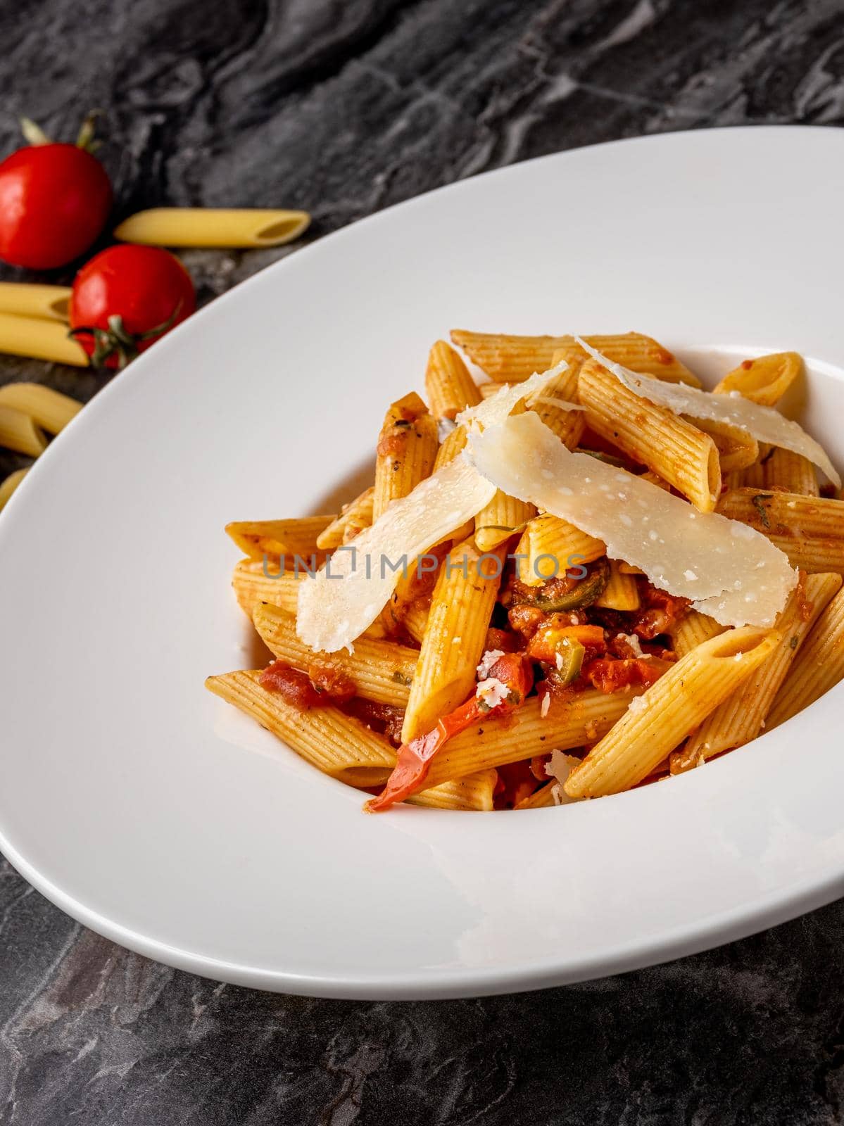 Penne pasta with a spicy sauce, chili pepper and grated parmesan cheese