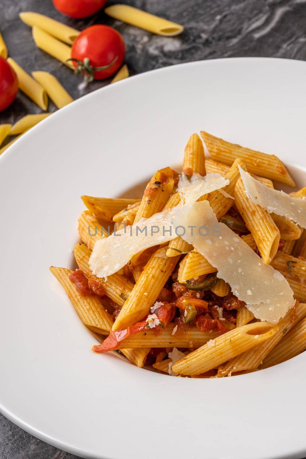 Penne pasta with a spicy sauce, chili pepper and grated parmesan cheese