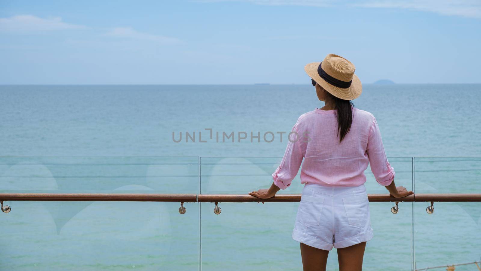 Asian women with a hat by the swimming pool in Pattaya Thailand Ban Amphur beach, women on a luxury vacation