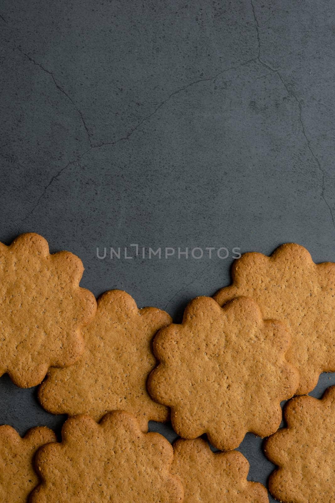 Fresh ginger biscuits piled on dark stone background