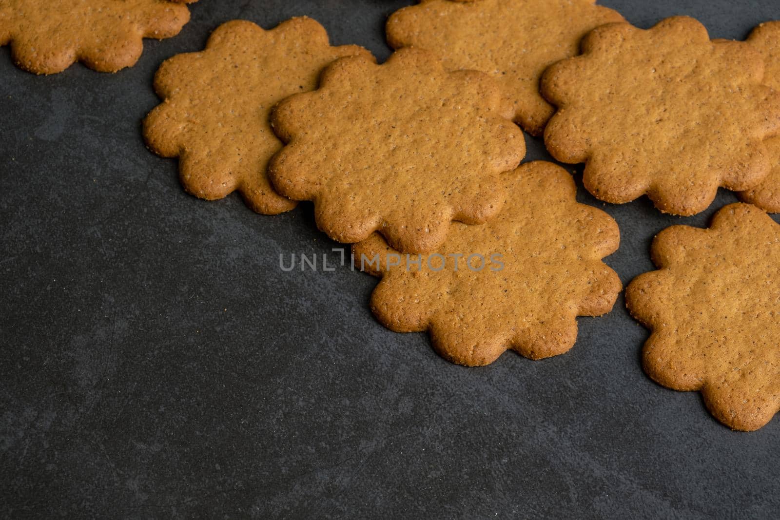 Fresh ginger biscuits piled on dark stone background