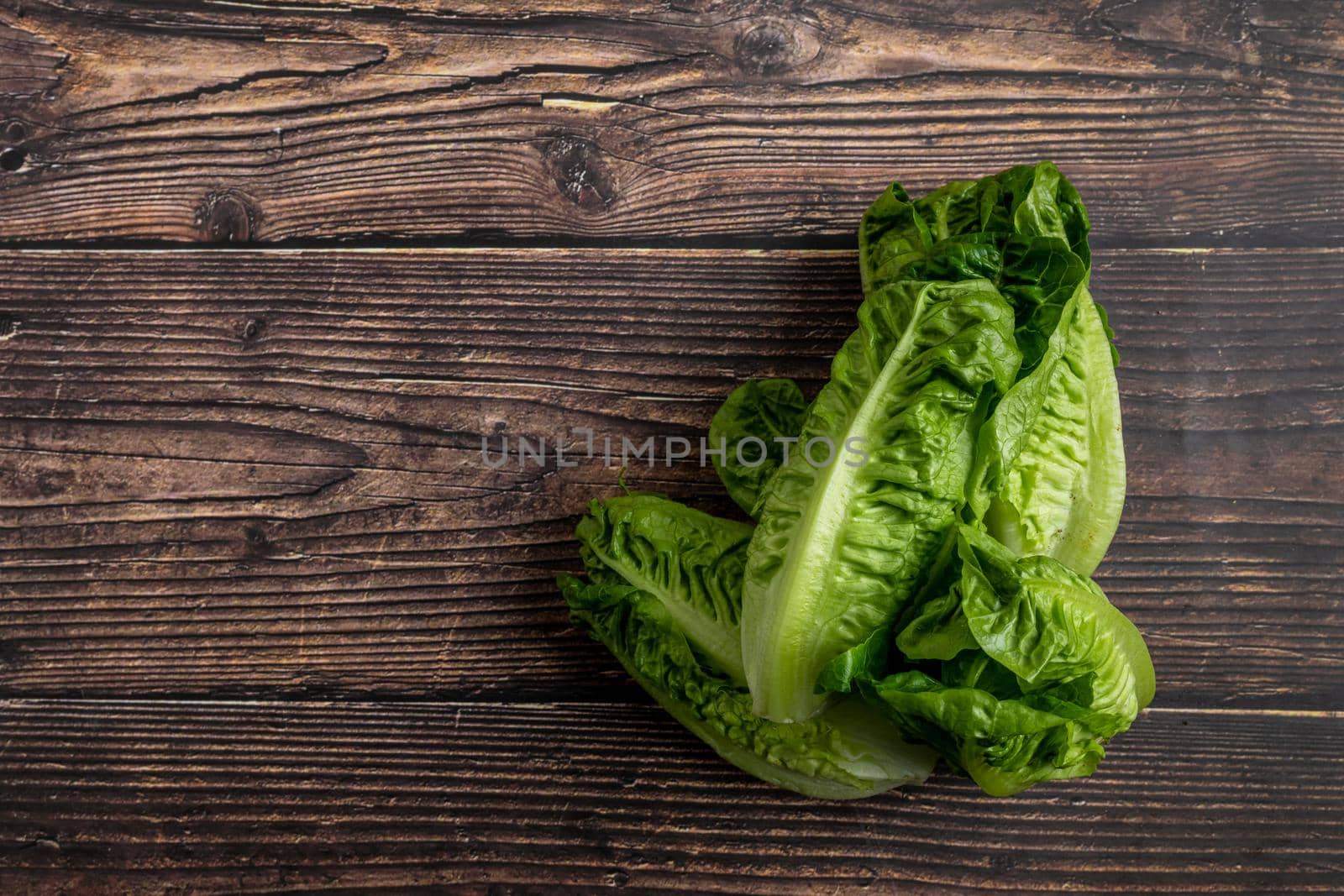 Pile of Fresh mini lettuces on wooden background, copy space