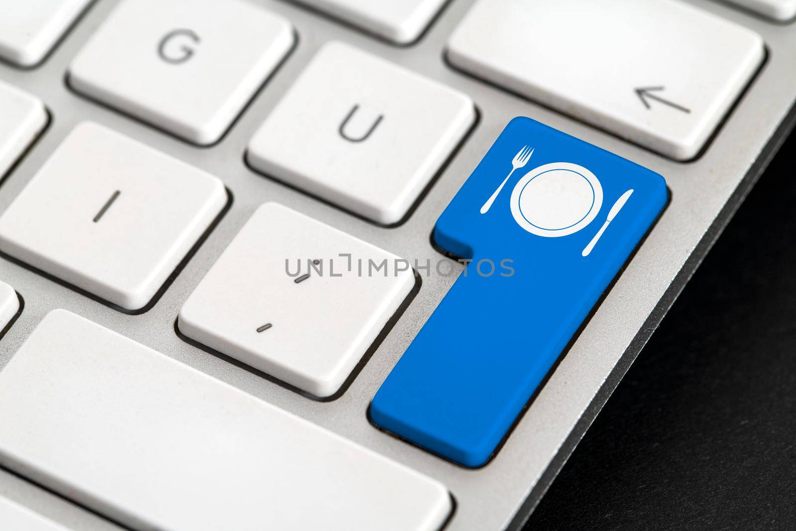 Online food order icon button with fork, knife and plate icons on silver keyboard