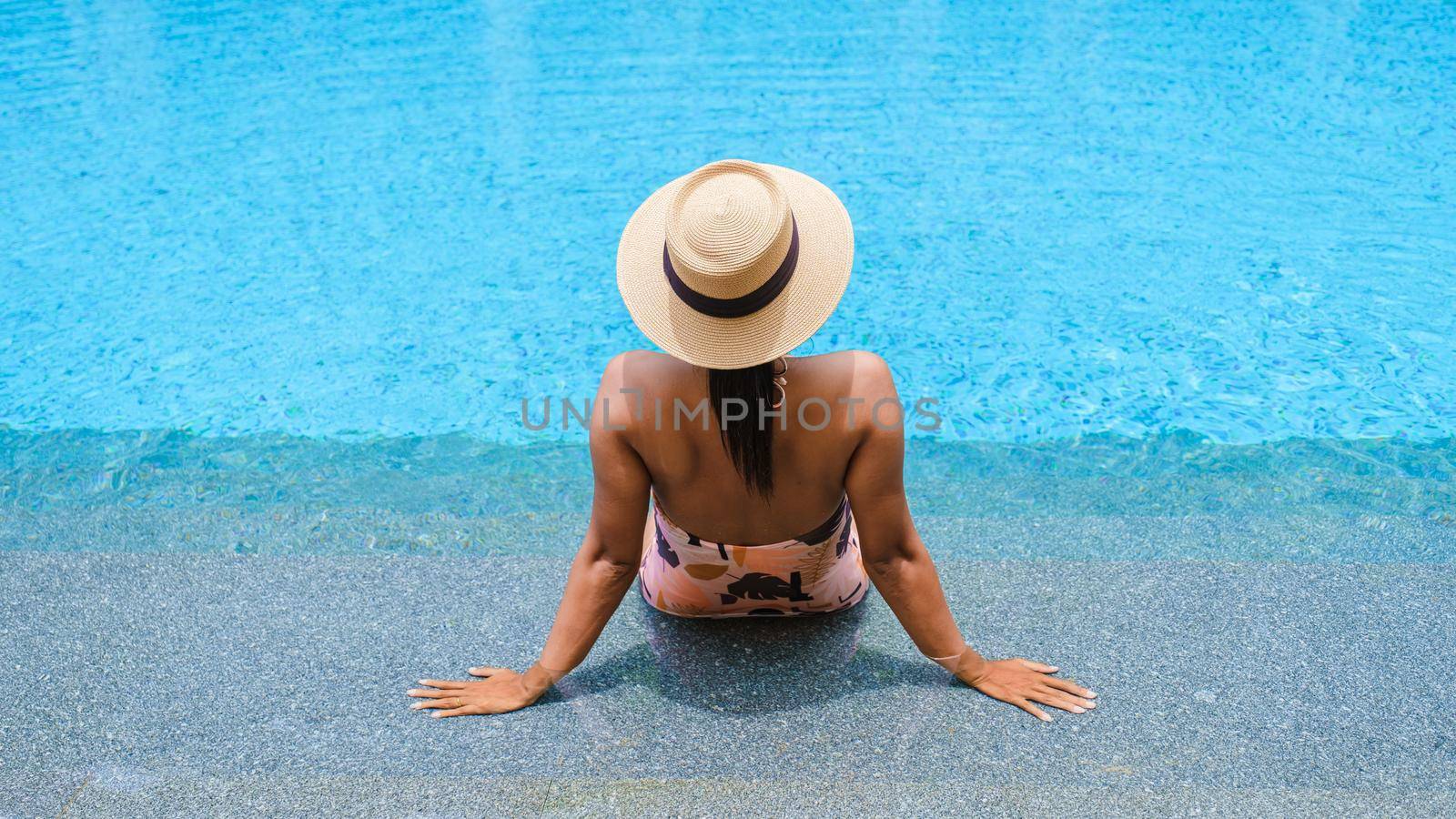 Asian women with hat relaxing in swimming pool, women swimming pool banner holiday vacation concept by fokkebok