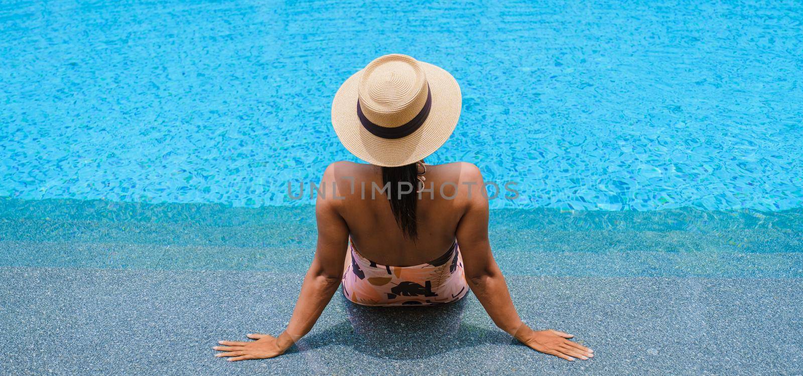 Asian women with hat relaxing in swimming pool, women swimming pool banner holiday vacation concept by fokkebok