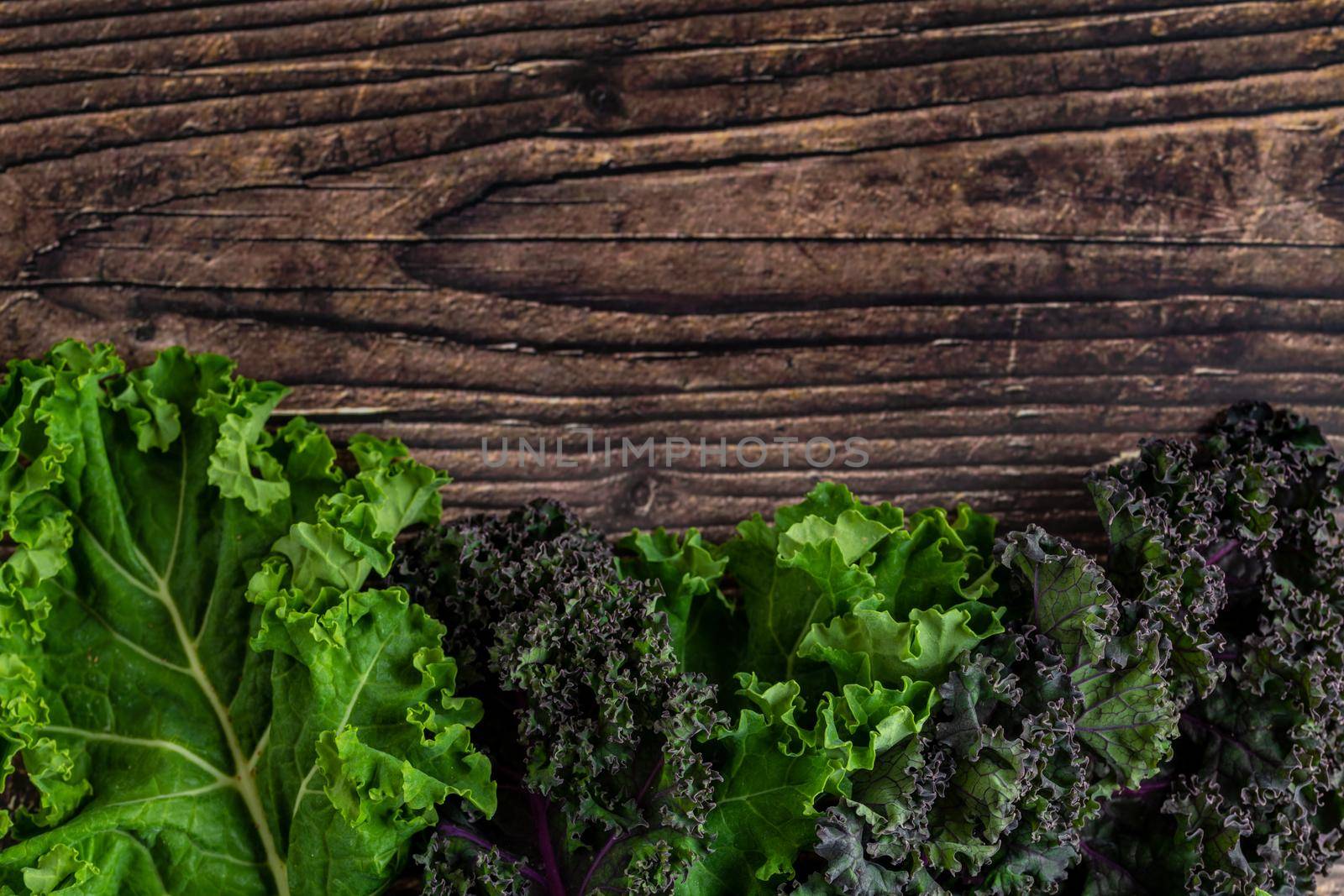 green leafy kale vegetable isolated on wooden table background