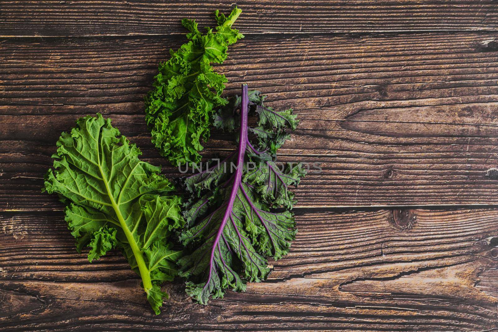 green leafy kale vegetable isolated on wooden table background