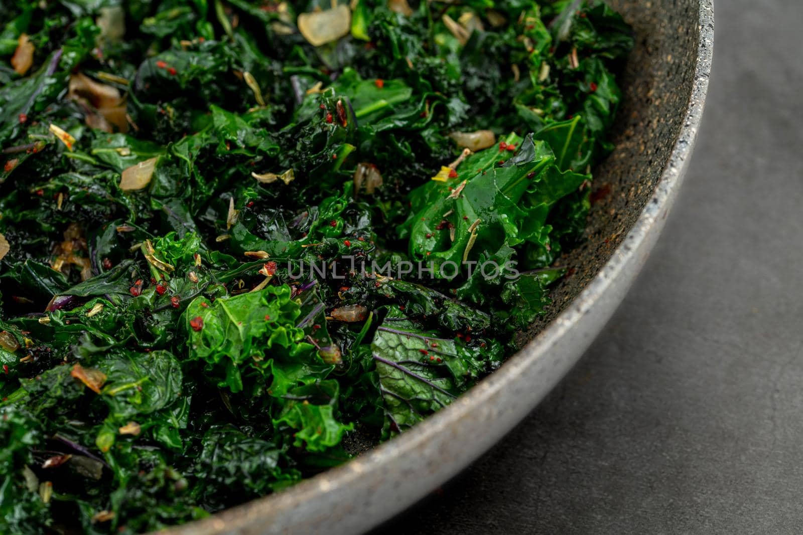 sauteed kale with onion in a pan with olive oil, healthy cooking concept