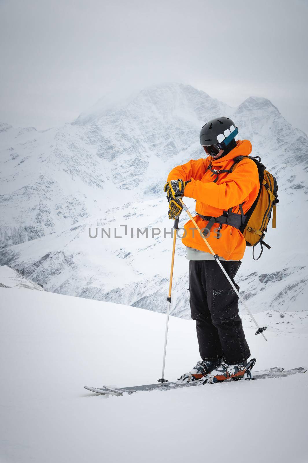 Portrait of a male skier at the top against the backdrop of epic mountains in the clouds. by yanik88