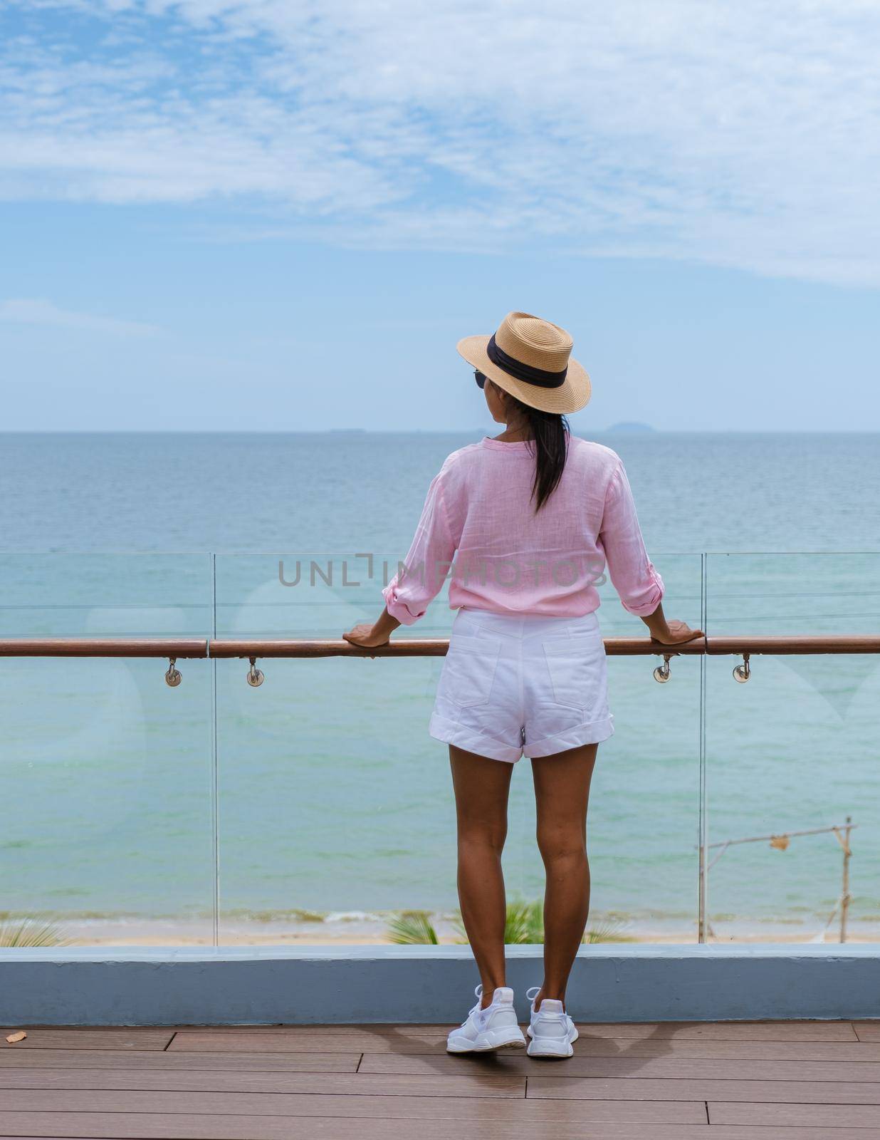 Asian women with a hat by the swimming pool in Pattaya Thailand Ban Amphur beach, women on a luxury vacation