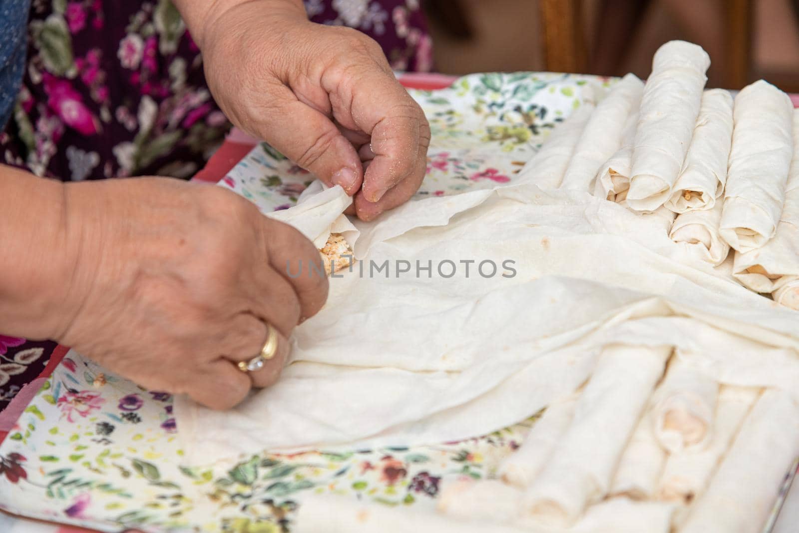 Housewife making putting cheese in yufka, make traditional Turkish sigara boregi (cigarette borek).