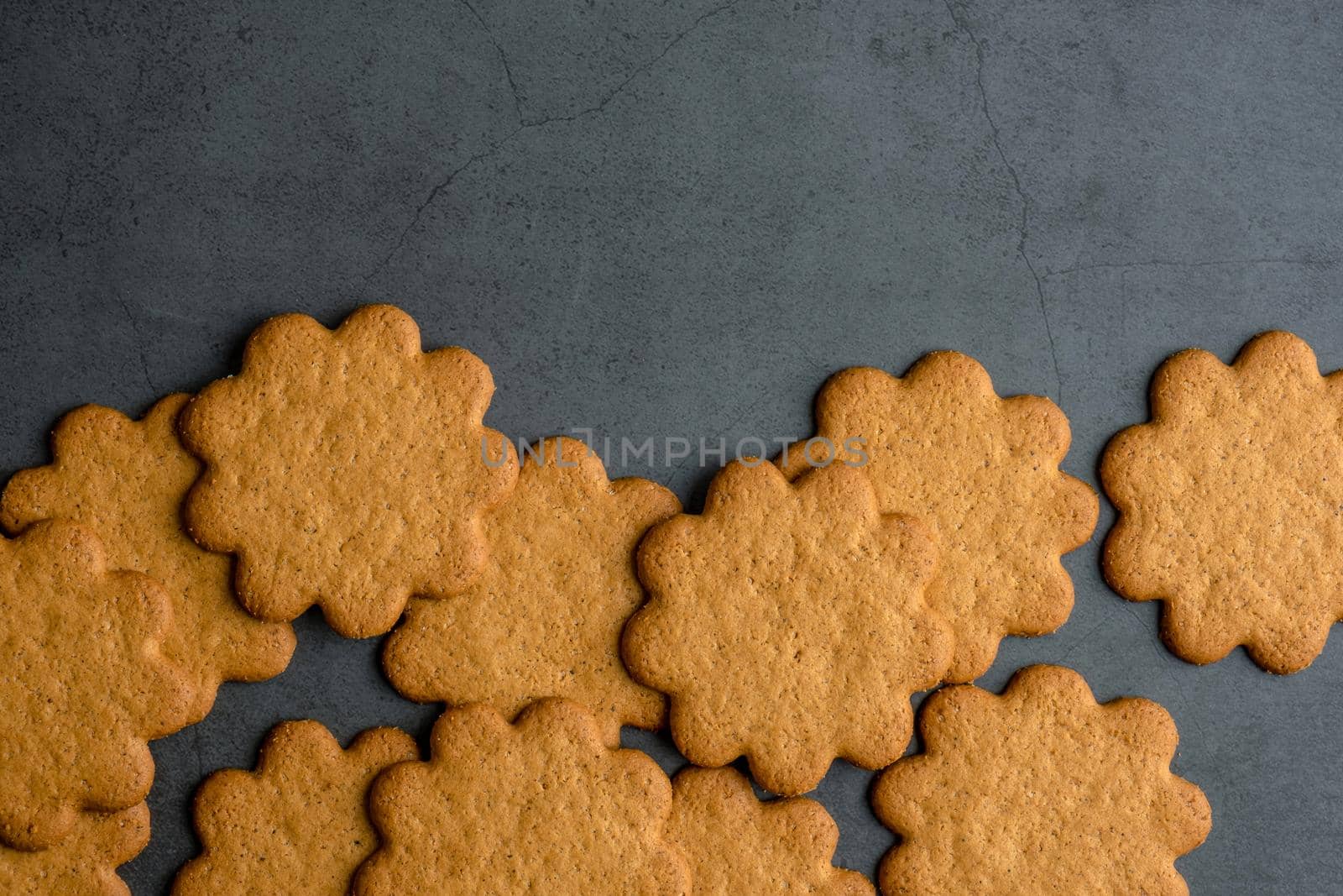 Fresh ginger biscuits piled on dark stone background