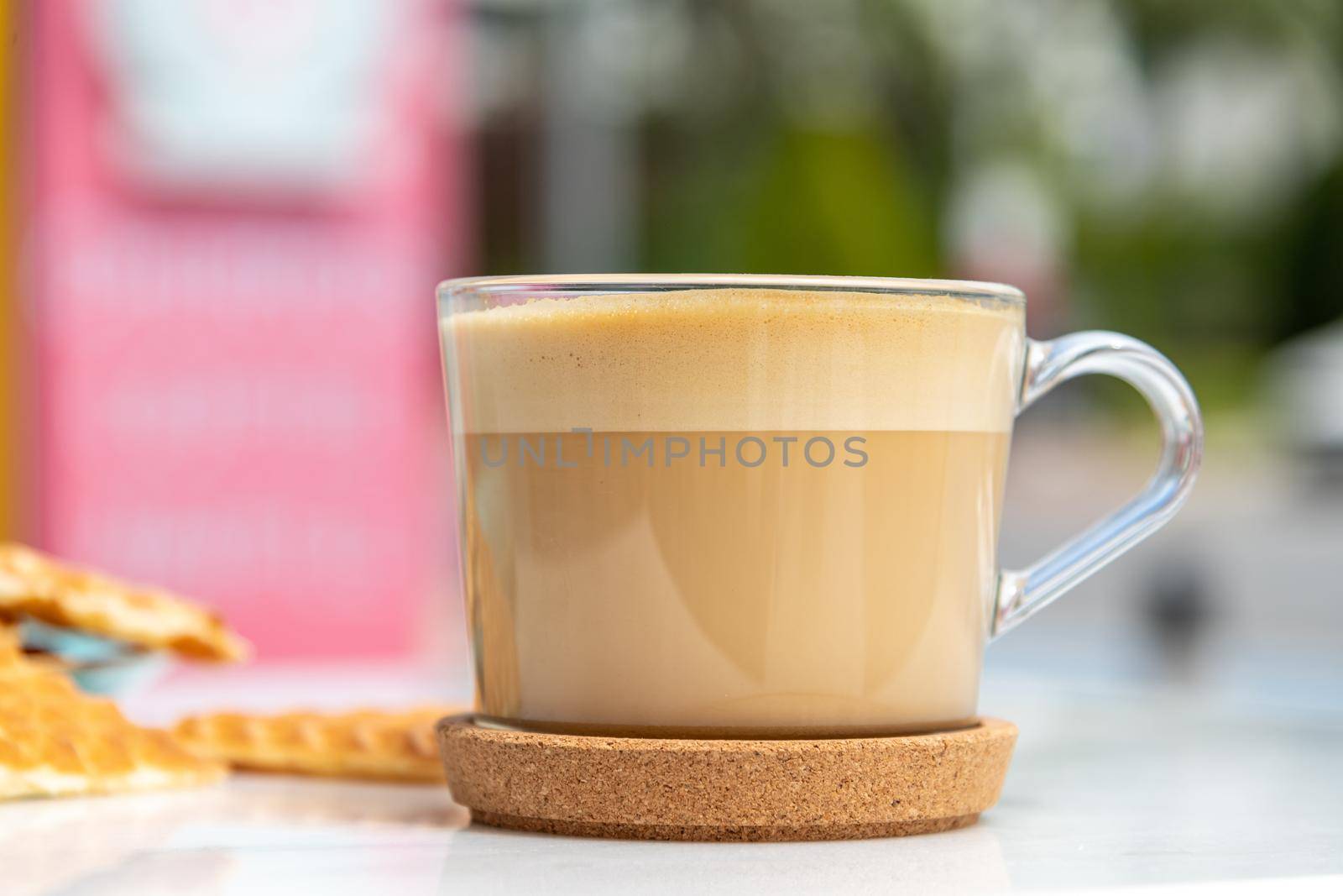 Cafe latte and heart waffles on marble table in the garden of the cafe by Sonat