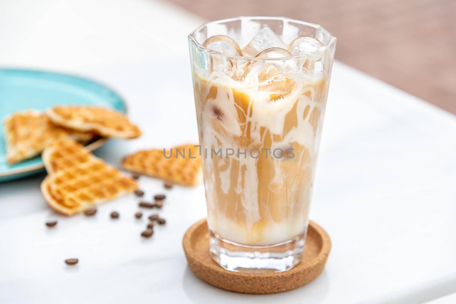 Iced caramel latte coffee in a tall glass with caramel syrup