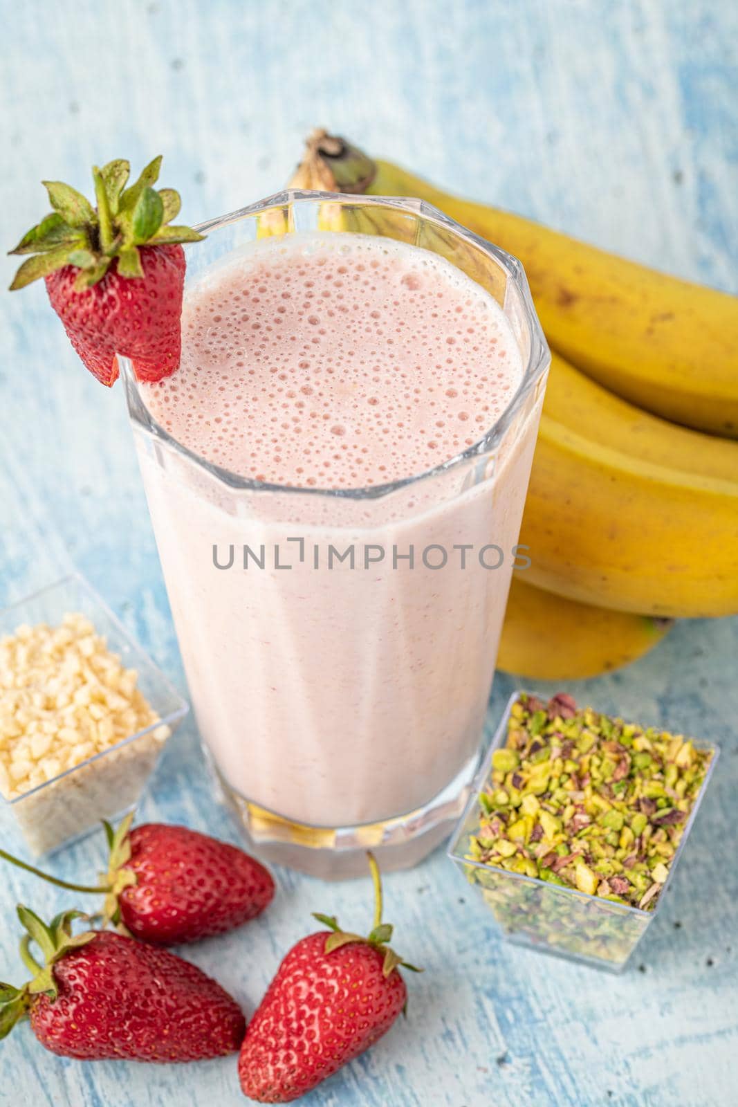 Strawberry and banana cold smoothie on blue background by Sonat