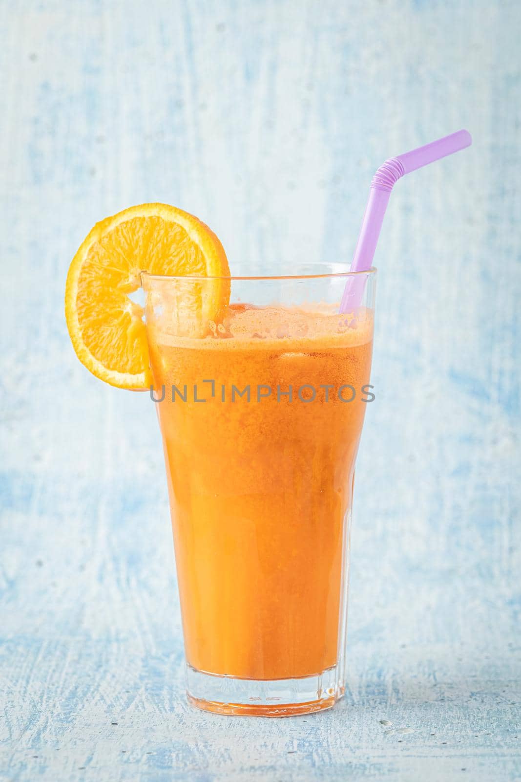 carrot and orange fresh juice on blue table by Sonat
