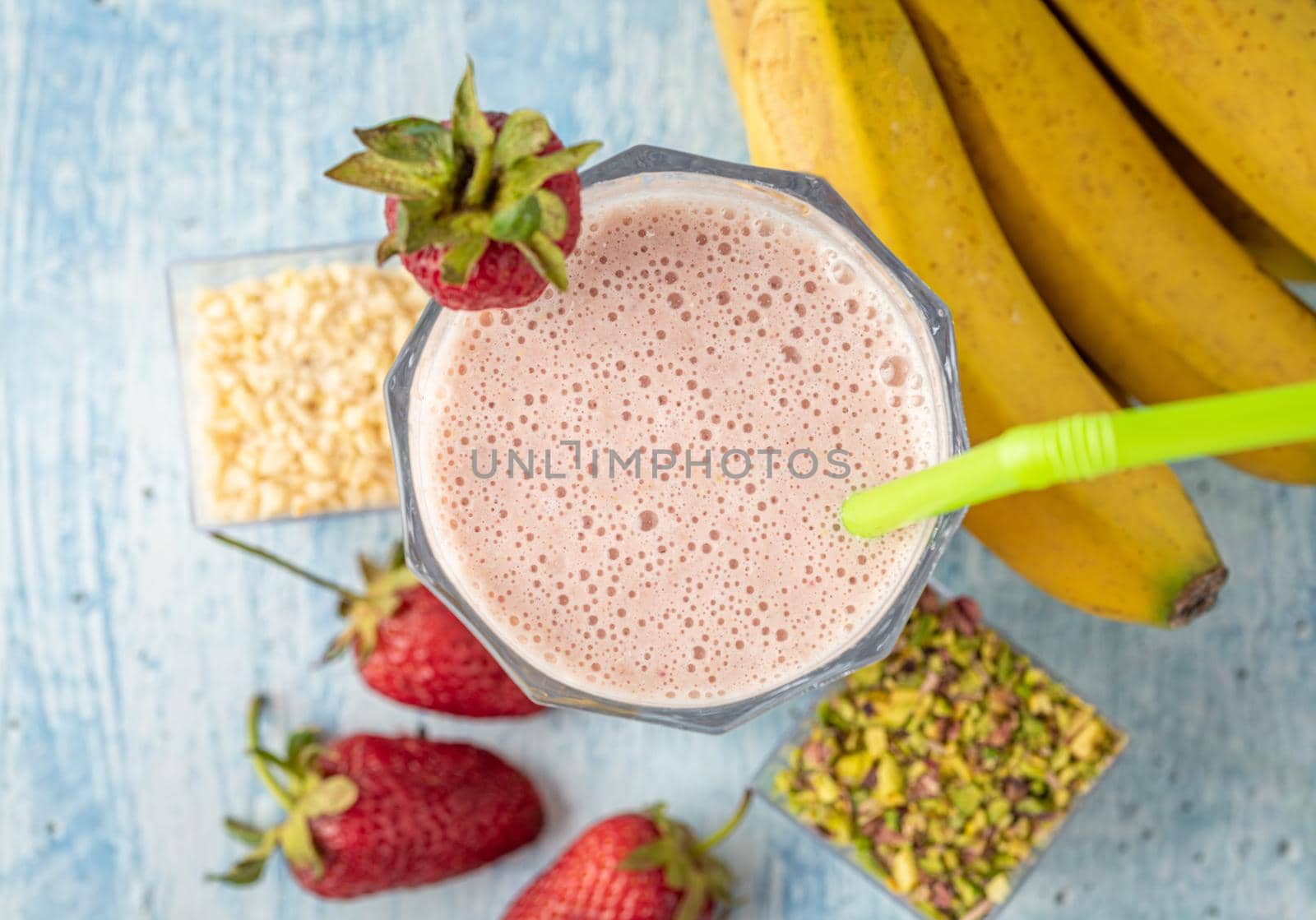 Strawberry and banana cold smoothie on blue background