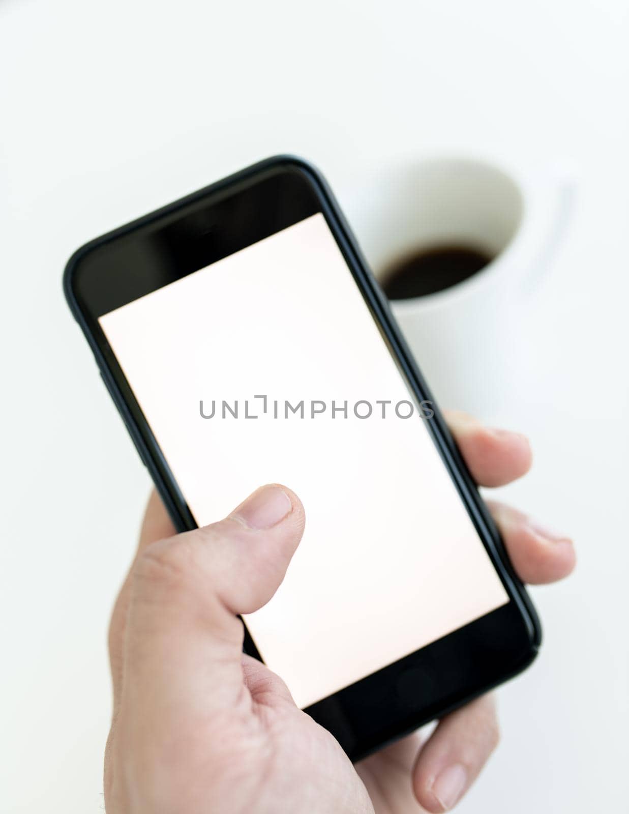 Man hand holding and touching screen of cellular phone with his thumb