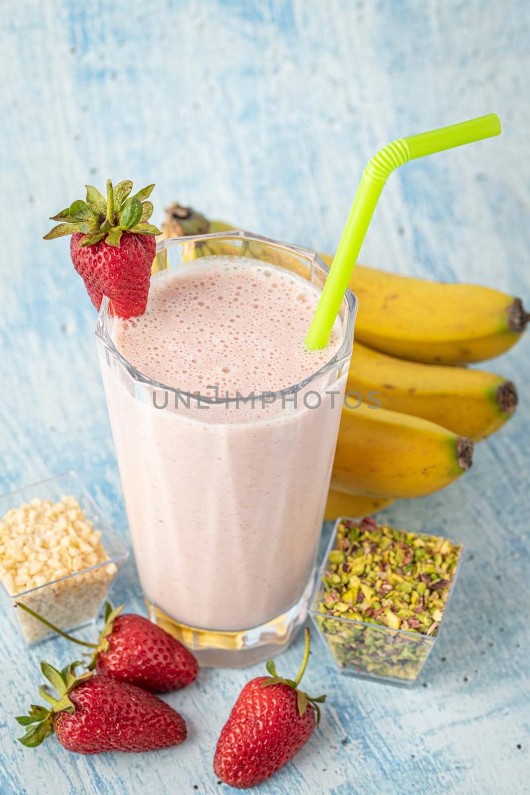Strawberry and banana cold smoothie on blue background by Sonat
