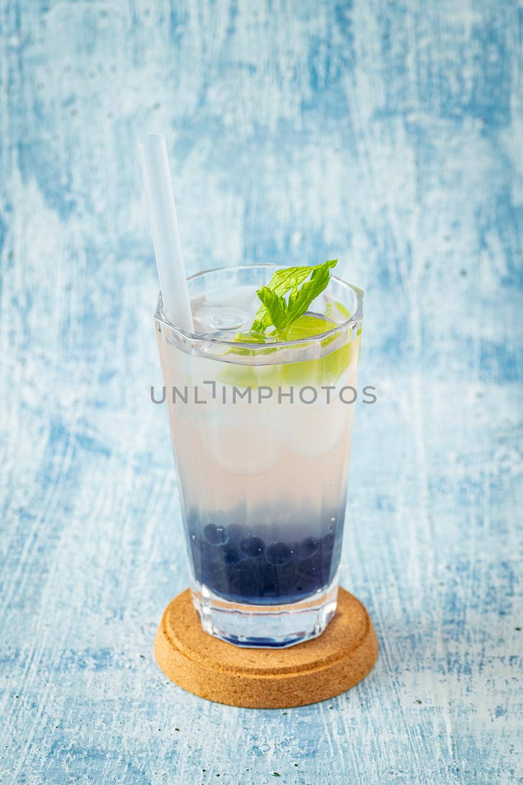 Fruity Bubble Tea in glass cup on blue background by Sonat