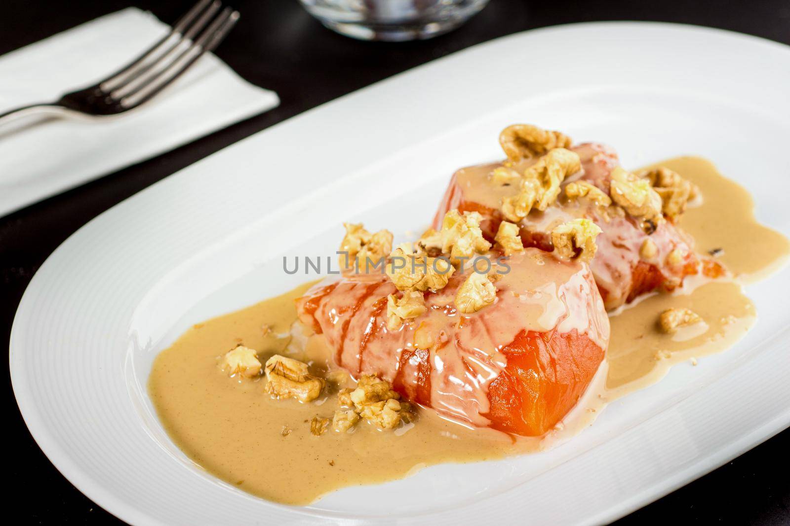 Pumpkin dessert with tahini and walnuts on a white porcelain plate