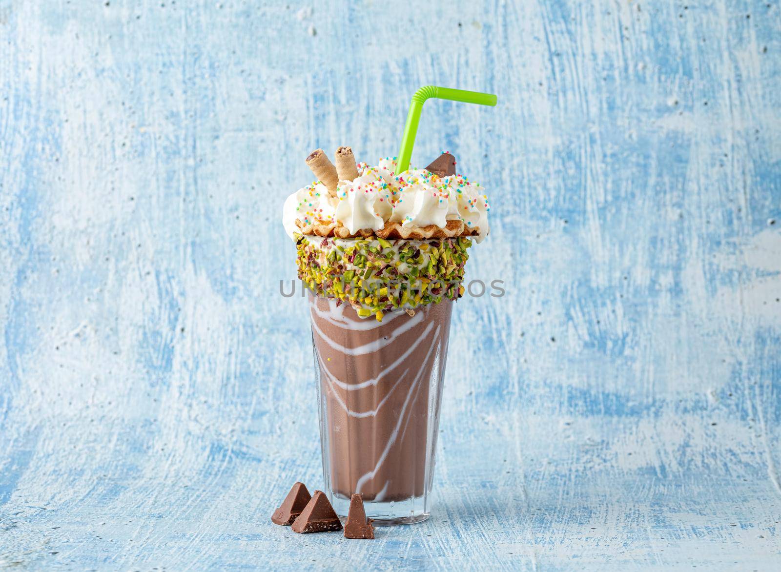 Cream and chocolate milkshake on blue background by Sonat