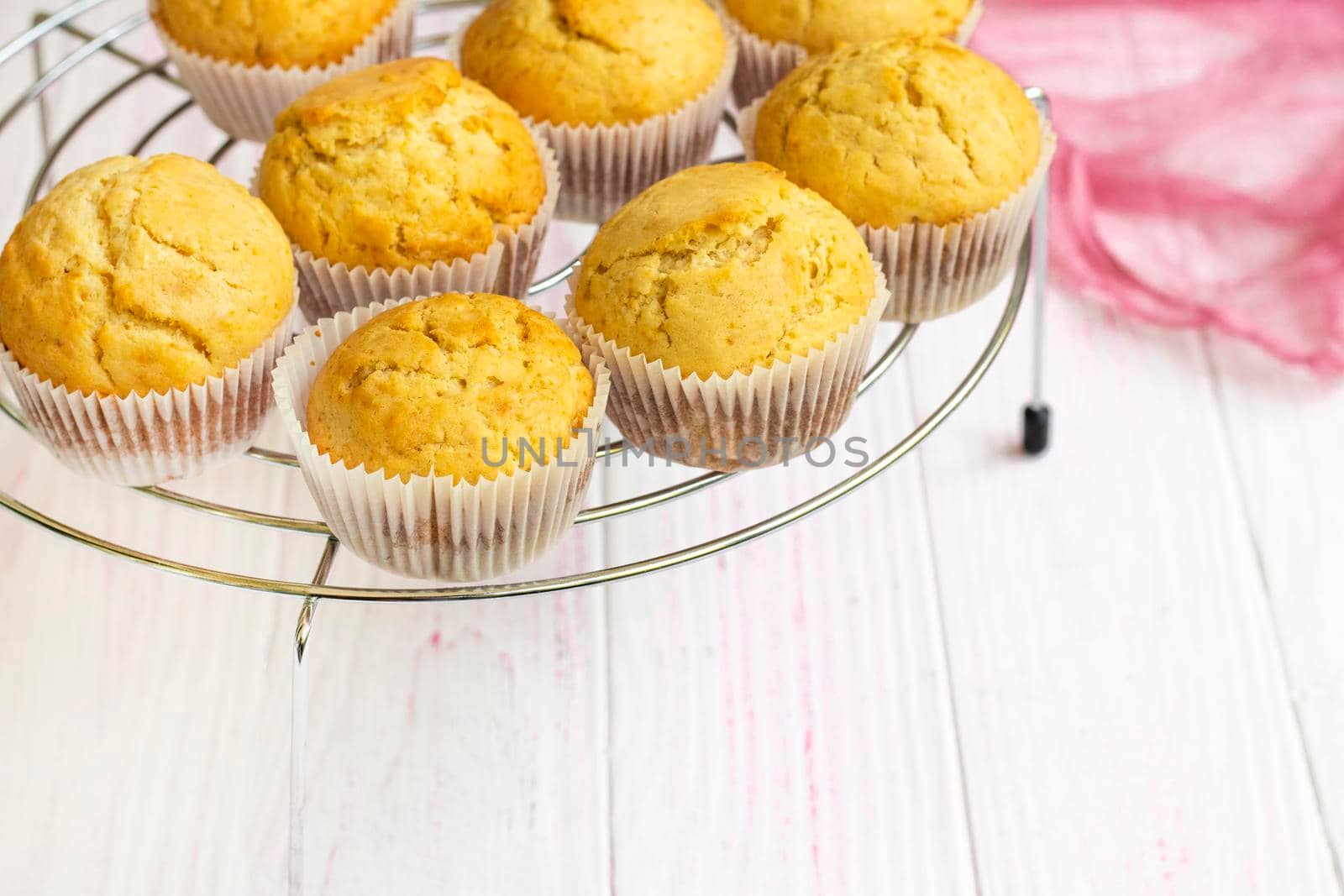 selective focus. fresh muffins cool on a cooling rack. Homemade vanilla cupcakes. Biscuit dessert prepared in the home kitchen. Hot white flour cupcakes. hot homemade cakes ready to decorate