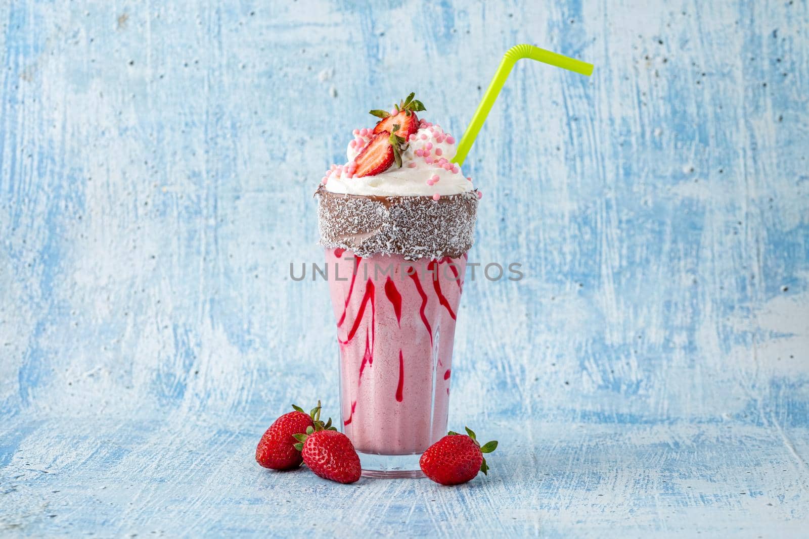 Refreshing strawberry milkshake on blue stone background by Sonat