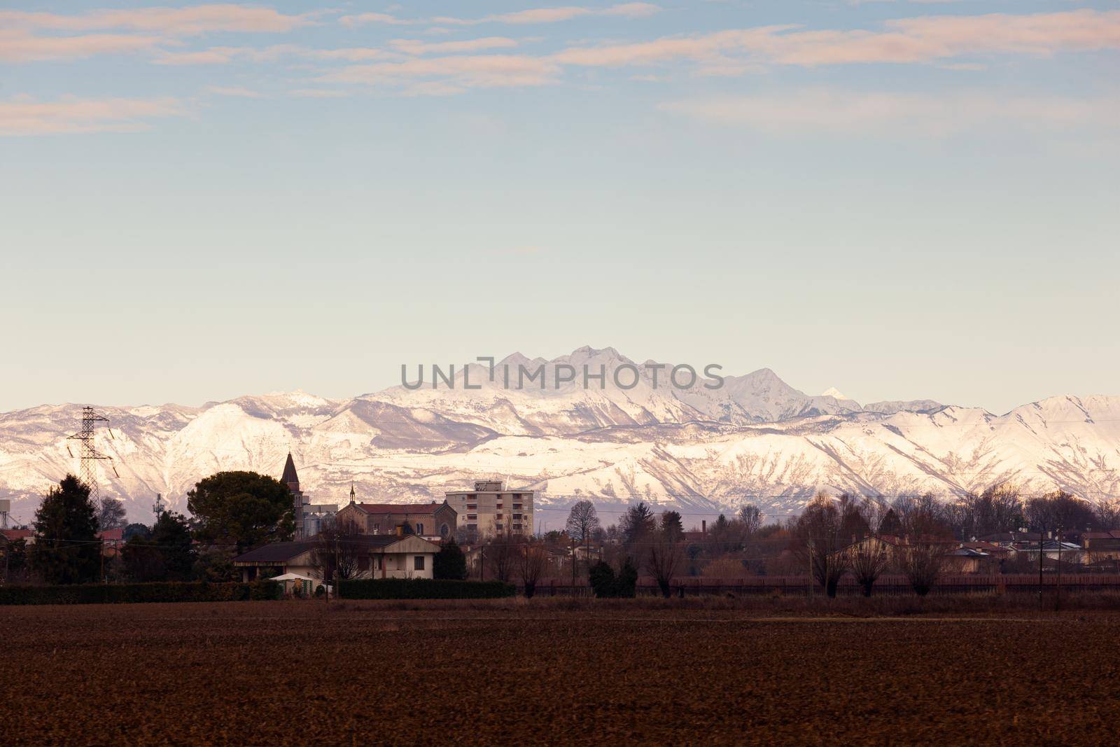 View of the Italian countryside with alp mountains on the background in the winter season