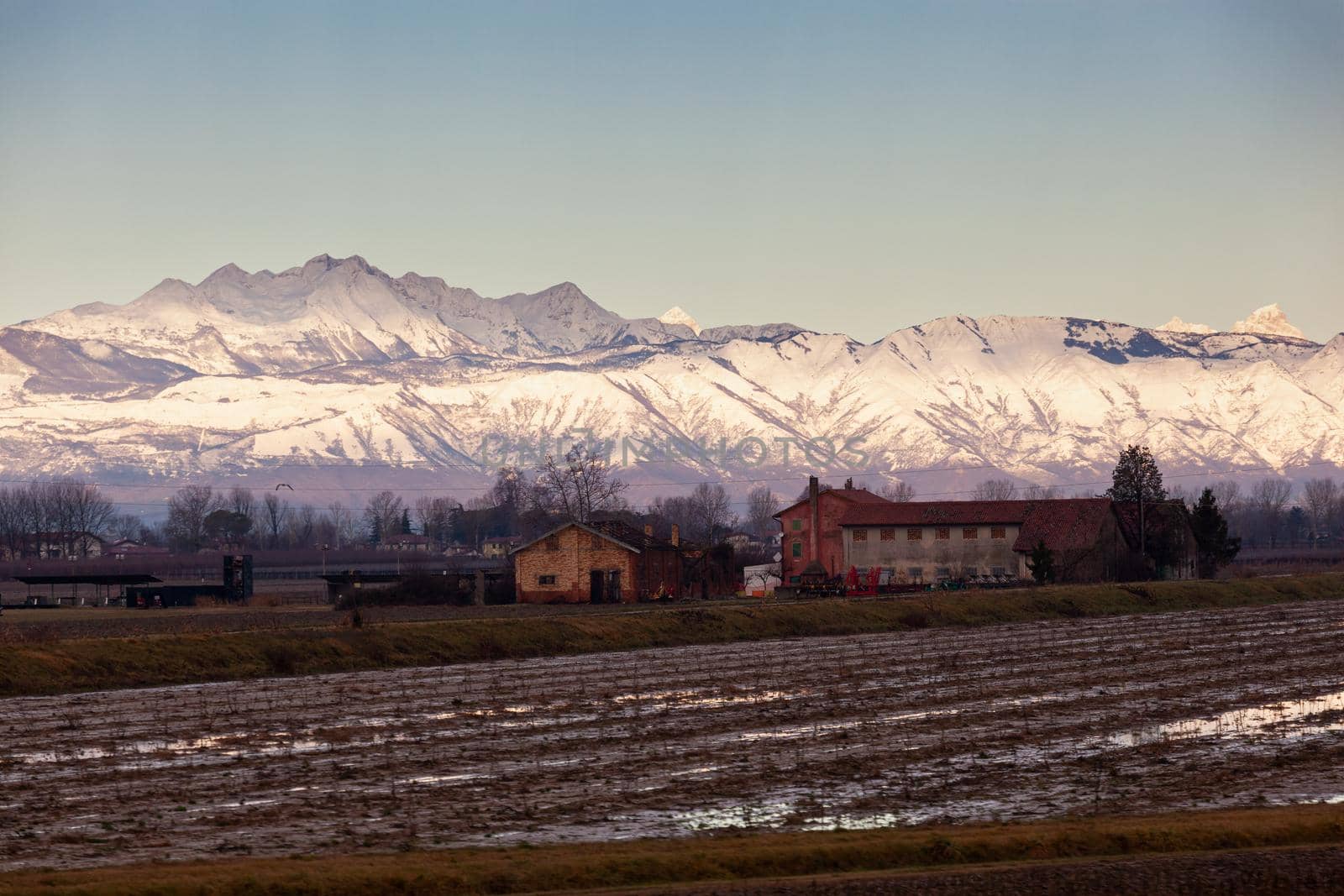 View of the Italian countryside with alp mountains on the background in the winter season