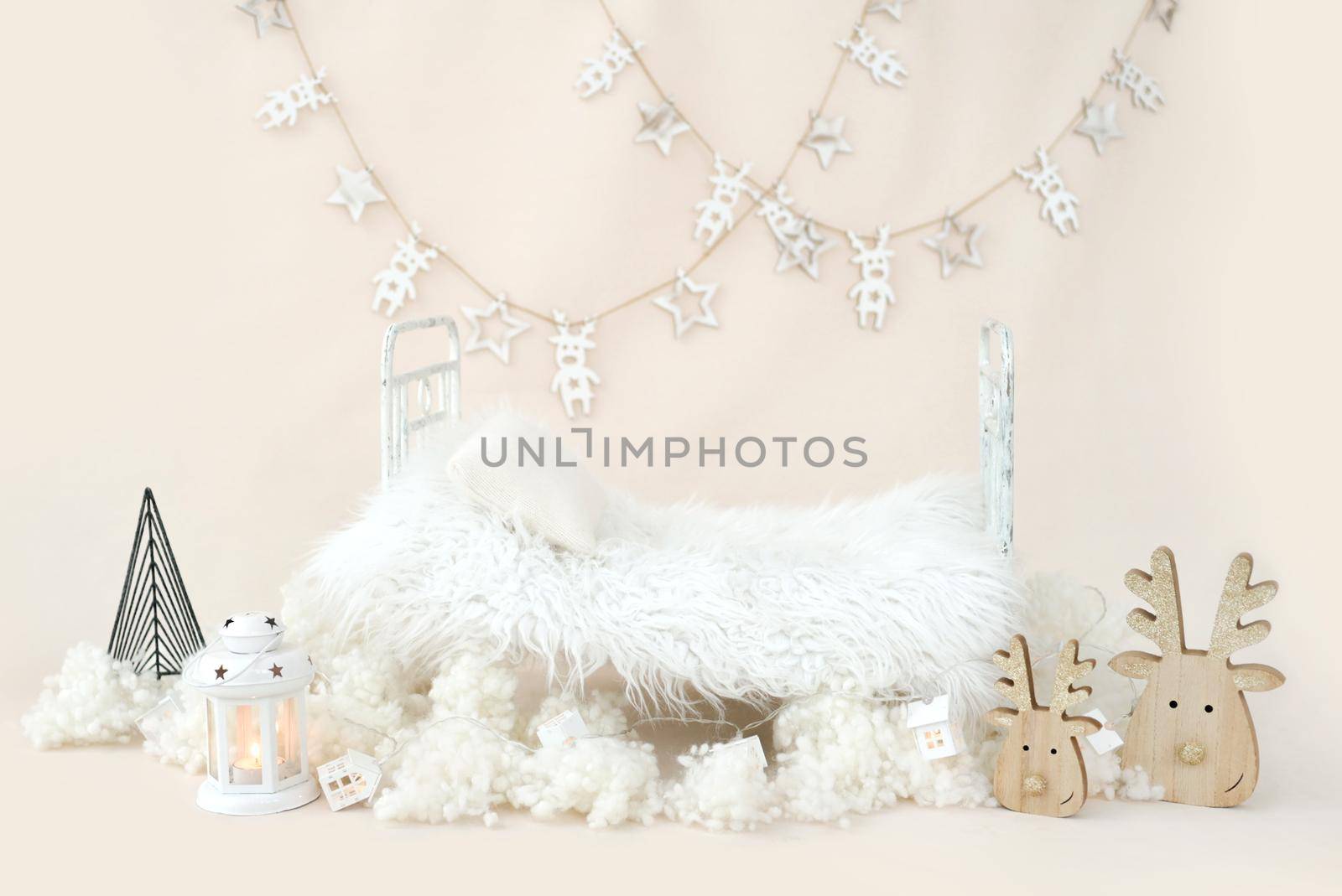 Newborn baby studio furniture bed for Christmas infant child photoshoot with white festive Xmas decoration. Tiny designed spot for kid New Year holiday studio portrait