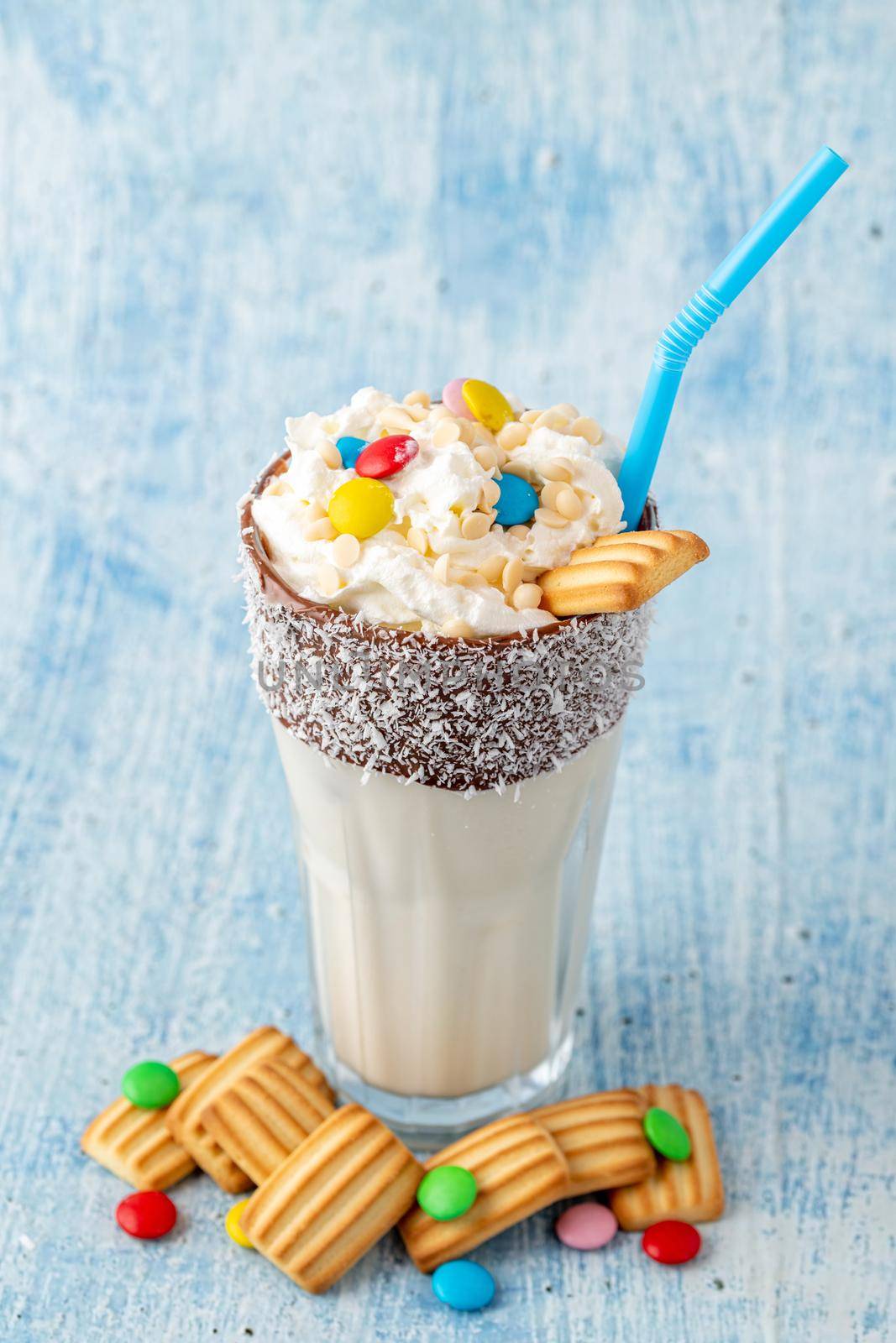 Milkshake with milk and baby biscuit decorated with dragee sugar.