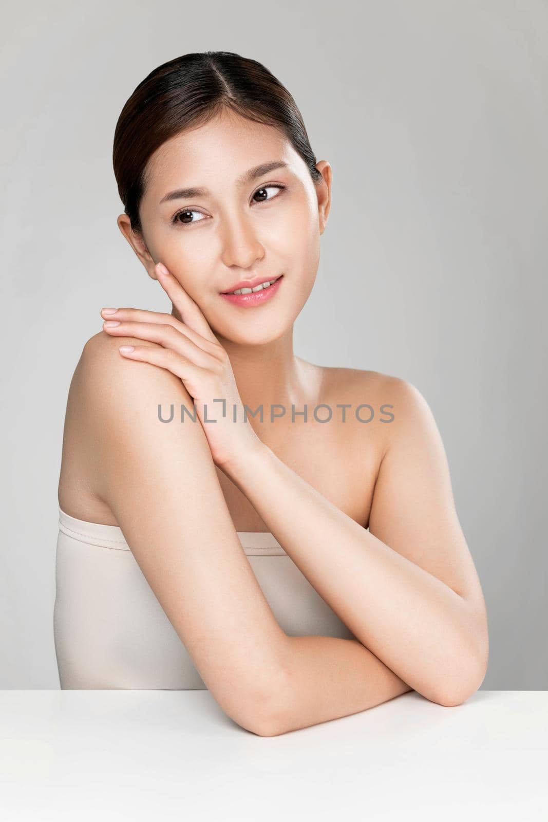 Portrait of ardent young woman with healthy clear skin and soft makeup looking at camera and posing beauty gesture. Cosmetology skincare and beauty concept.