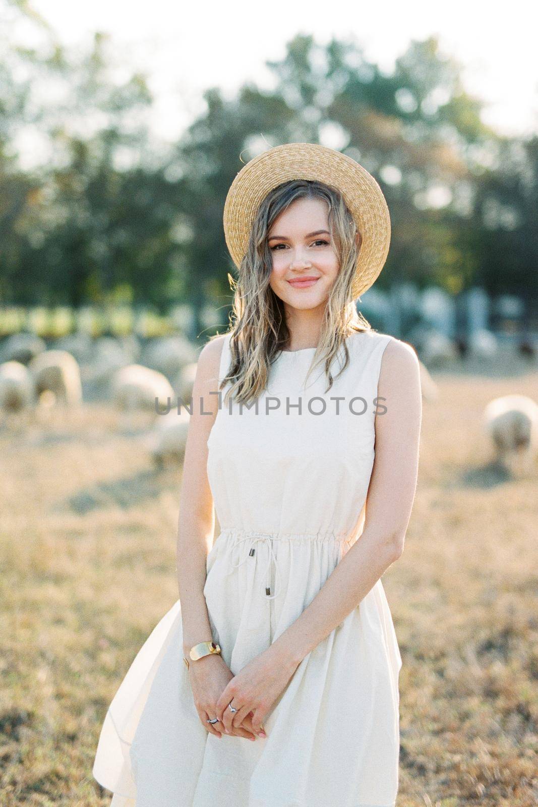 Girl in a straw hat stands on the lawn by Nadtochiy