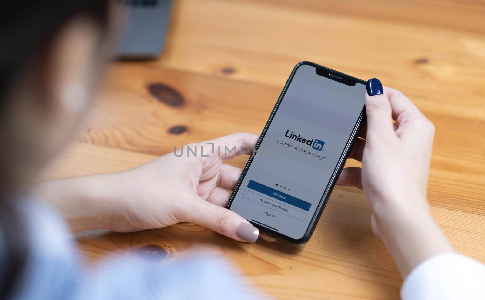 CHIANGMAI, THAILAND - AUG 18,2022 : A women holds Apple iPhone X with LinkedIn application on the screen.LinkedIn is a photo-sharing app for smartphones..