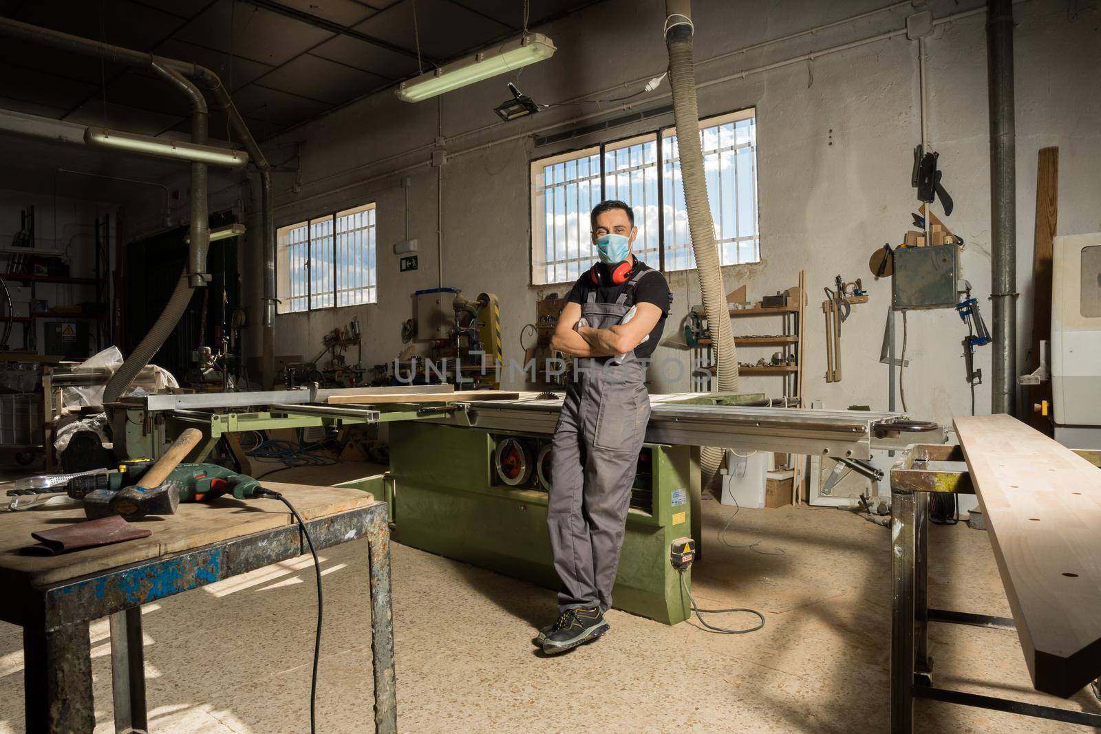 Worker looking at camera smiling in a factory. by ivanmoreno