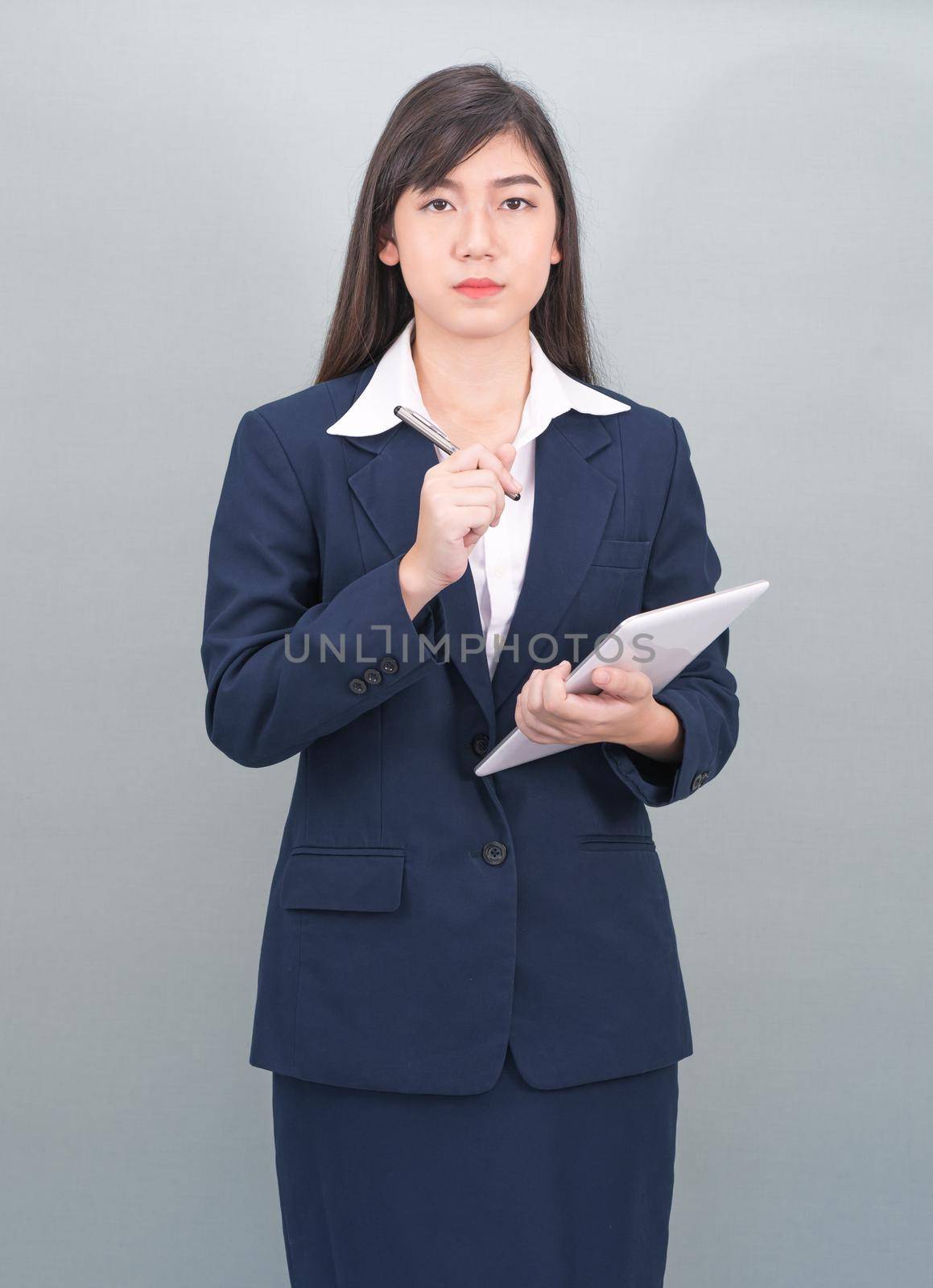 Woman in suit using computer digital tablet isolate on gray background