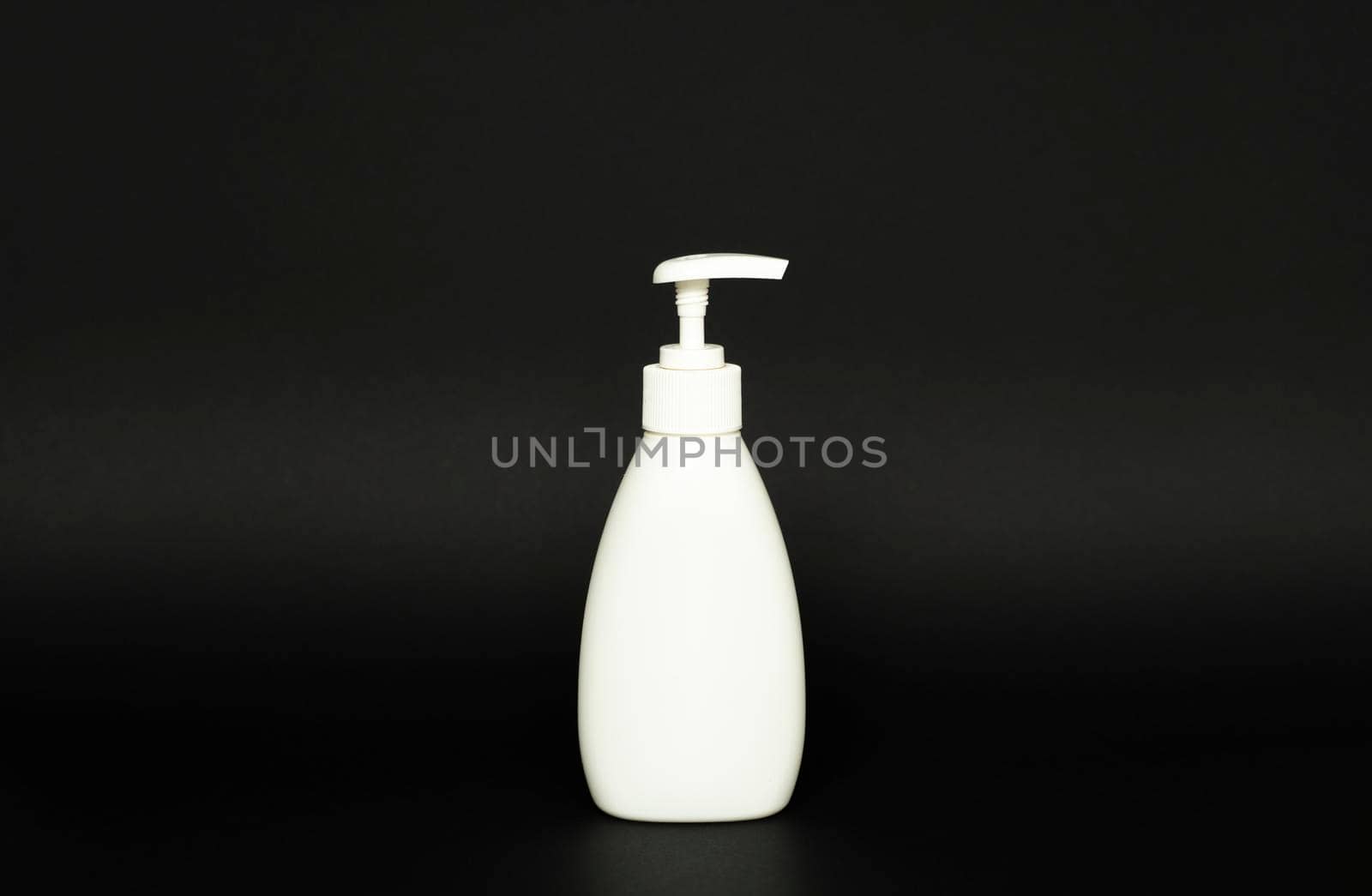 White plastic bottle with black dispenser, isolated on black background