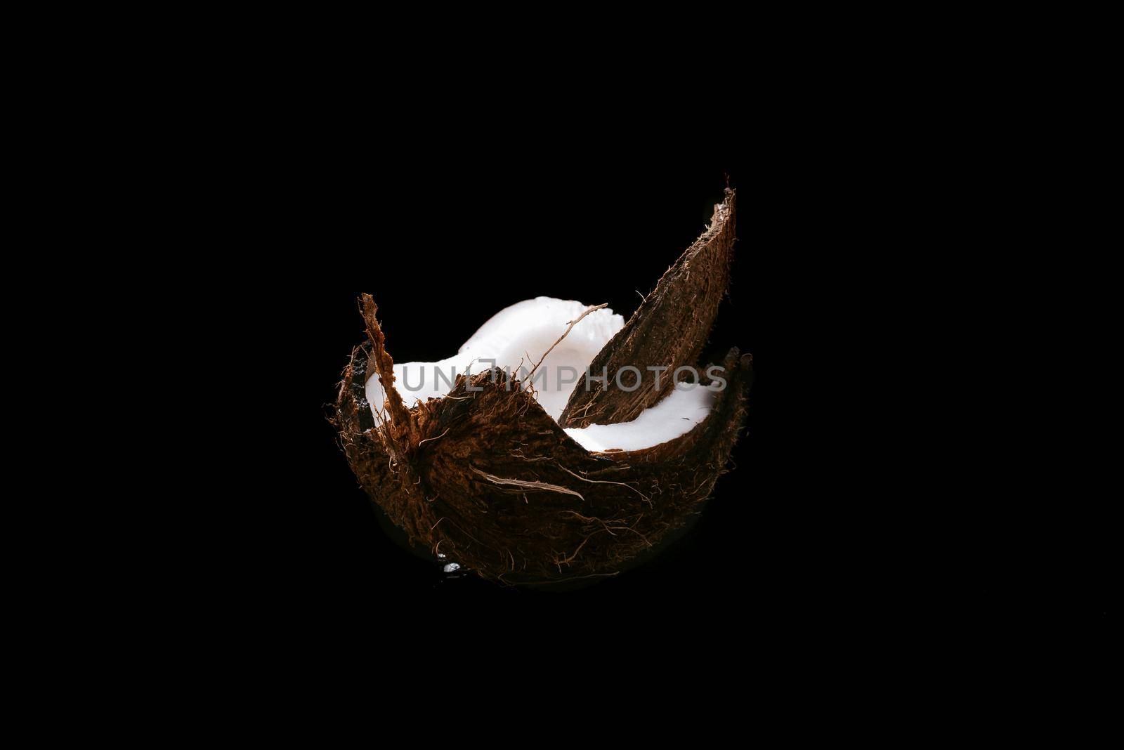Coconut on a black background isolated. Broken coconut.