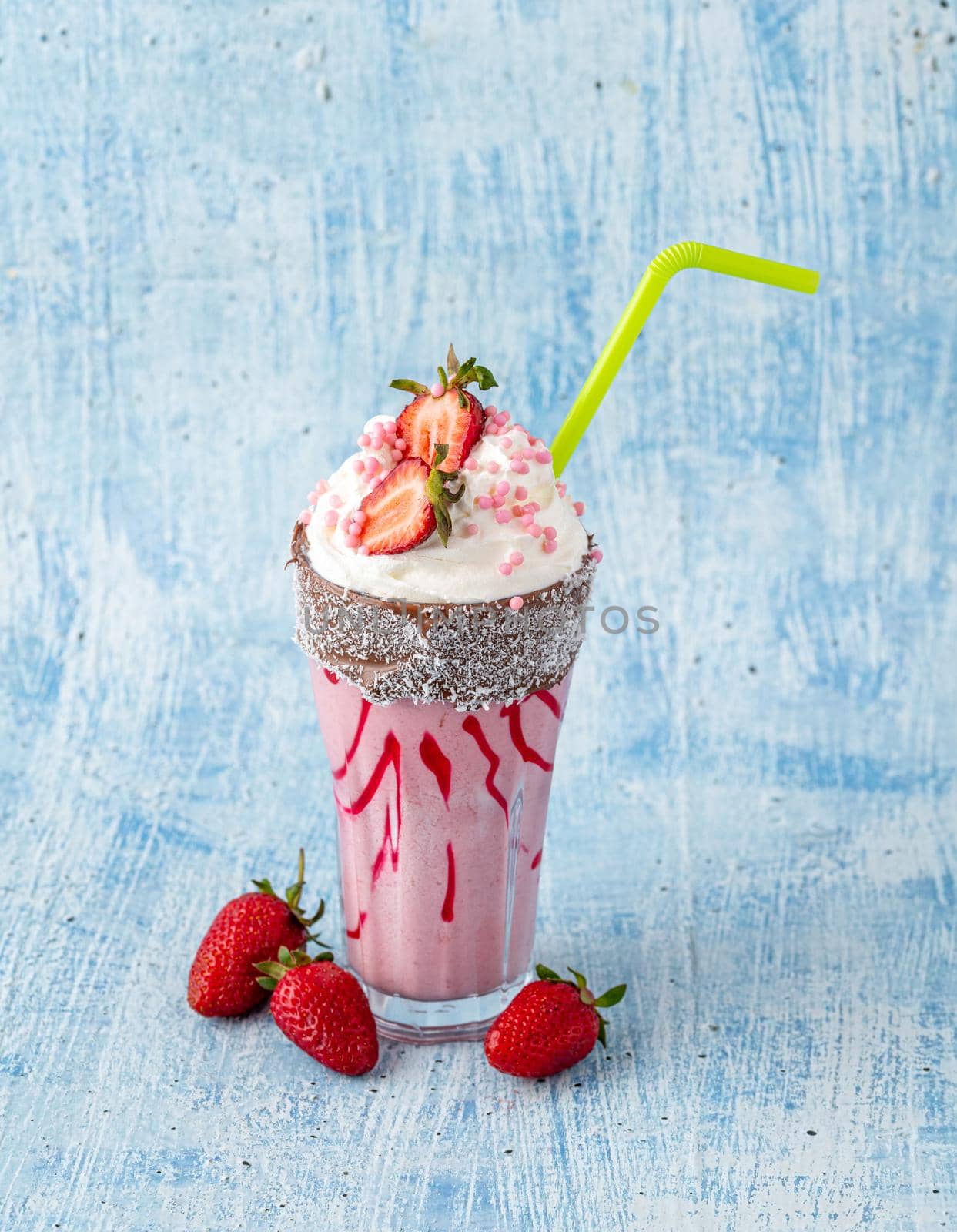 Refreshing strawberry milkshake on blue stone background by Sonat