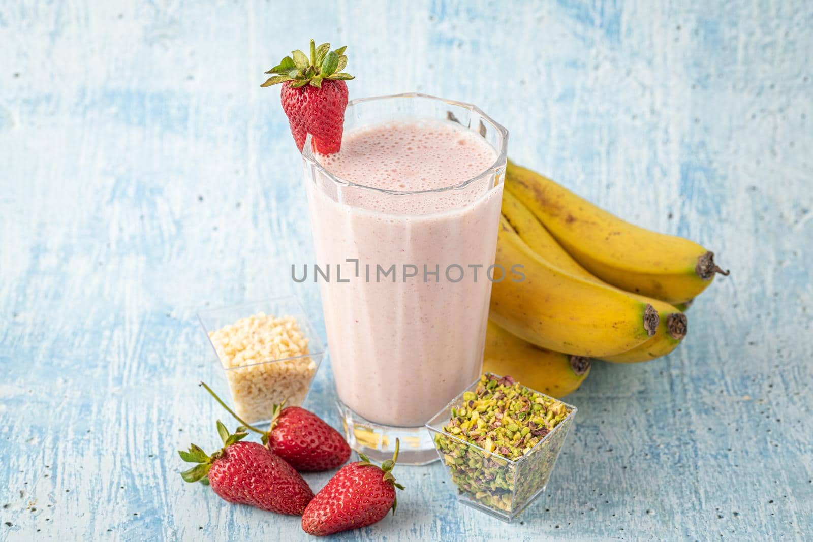 Strawberry and banana cold smoothie on blue background by Sonat