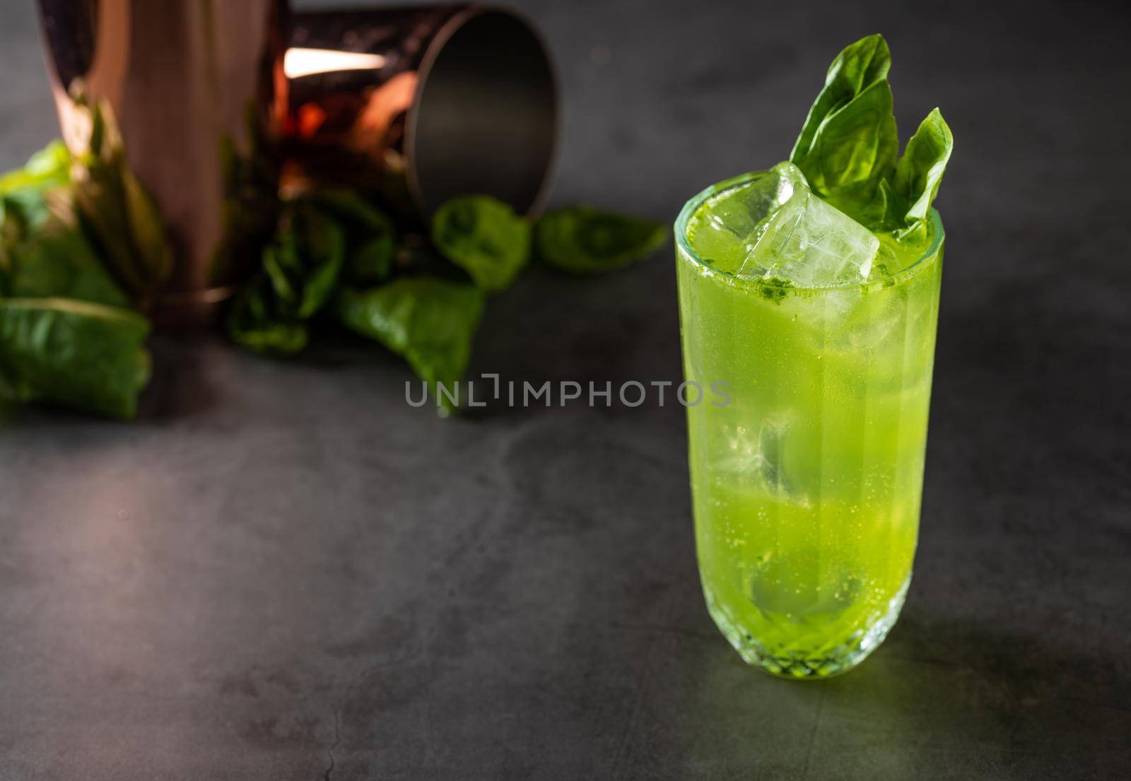 refreshing and light basil summer cocktail with ice cubes