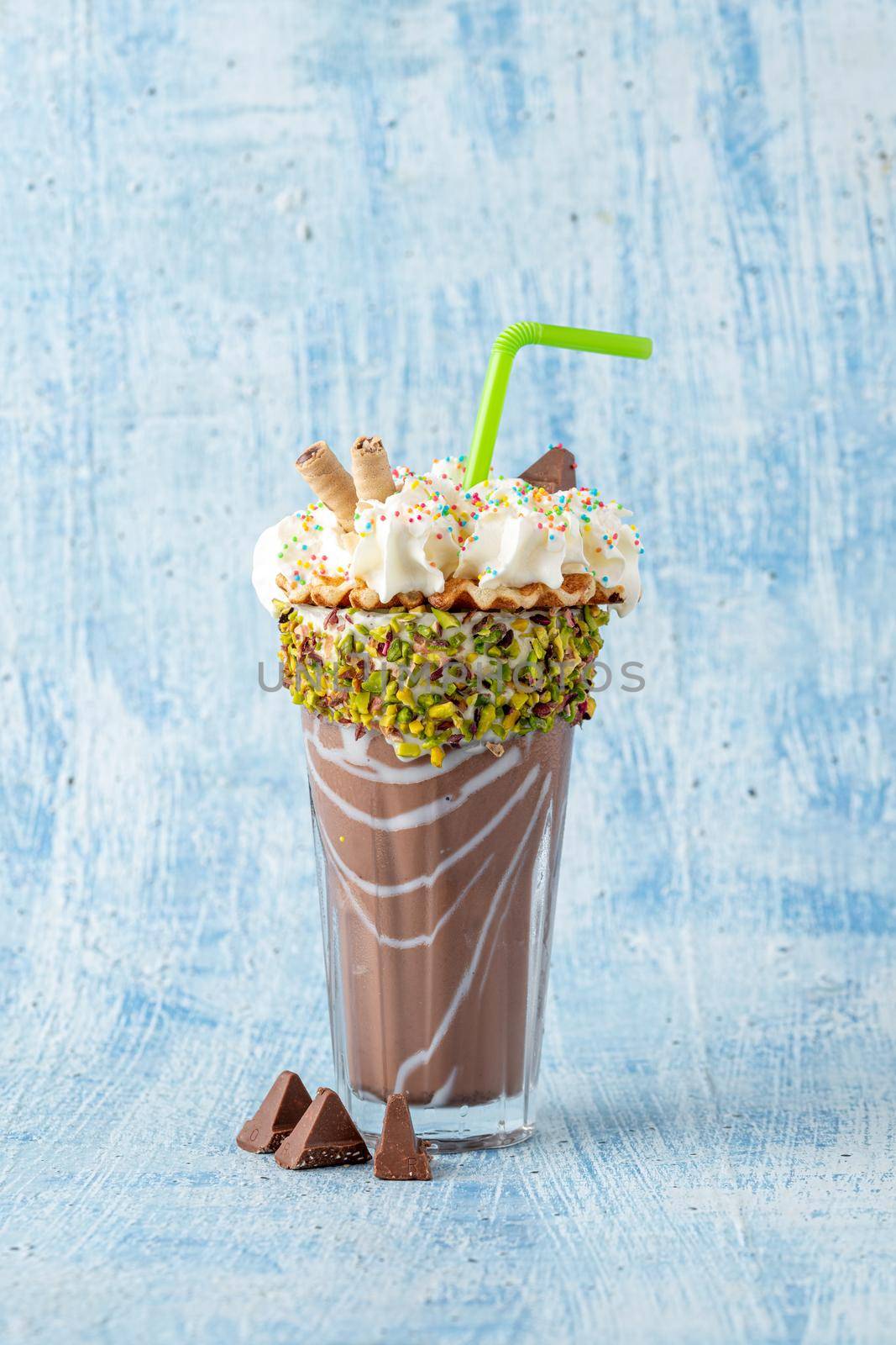 Cream and chocolate milkshake on blue background by Sonat