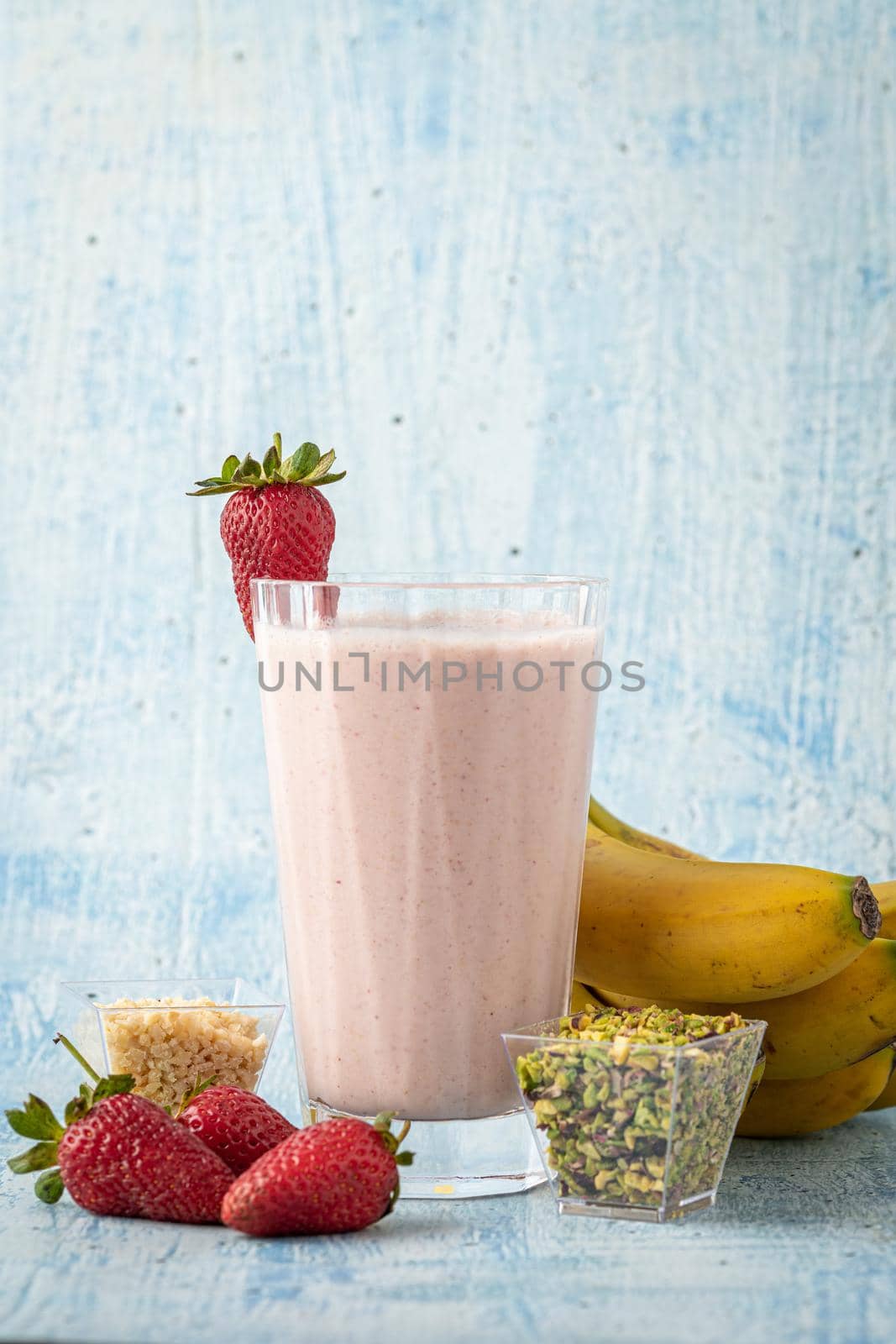 Strawberry and banana cold smoothie on blue background by Sonat