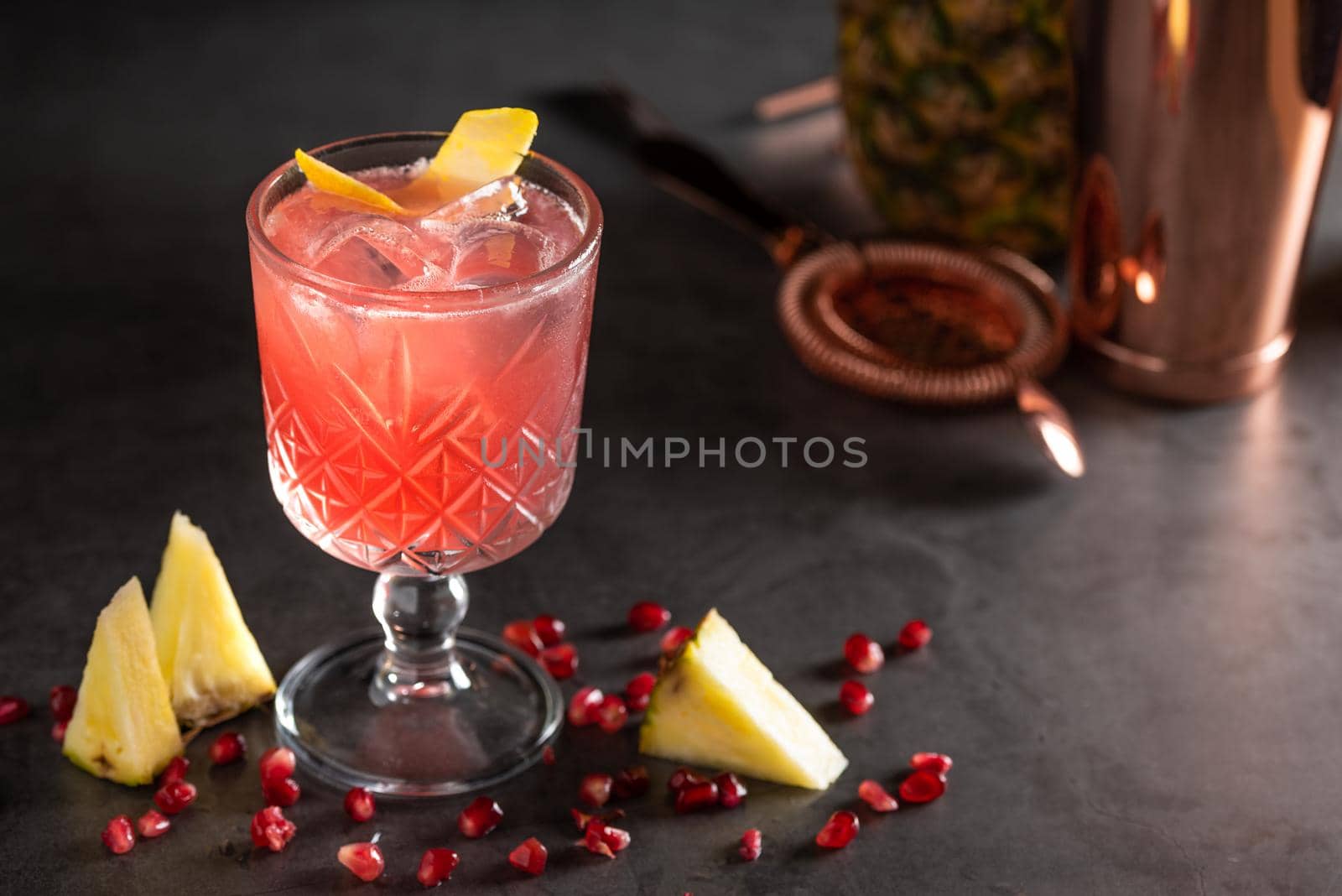 refreshing and light pomegranate and pineapple summer cocktail with ice cubes by Sonat