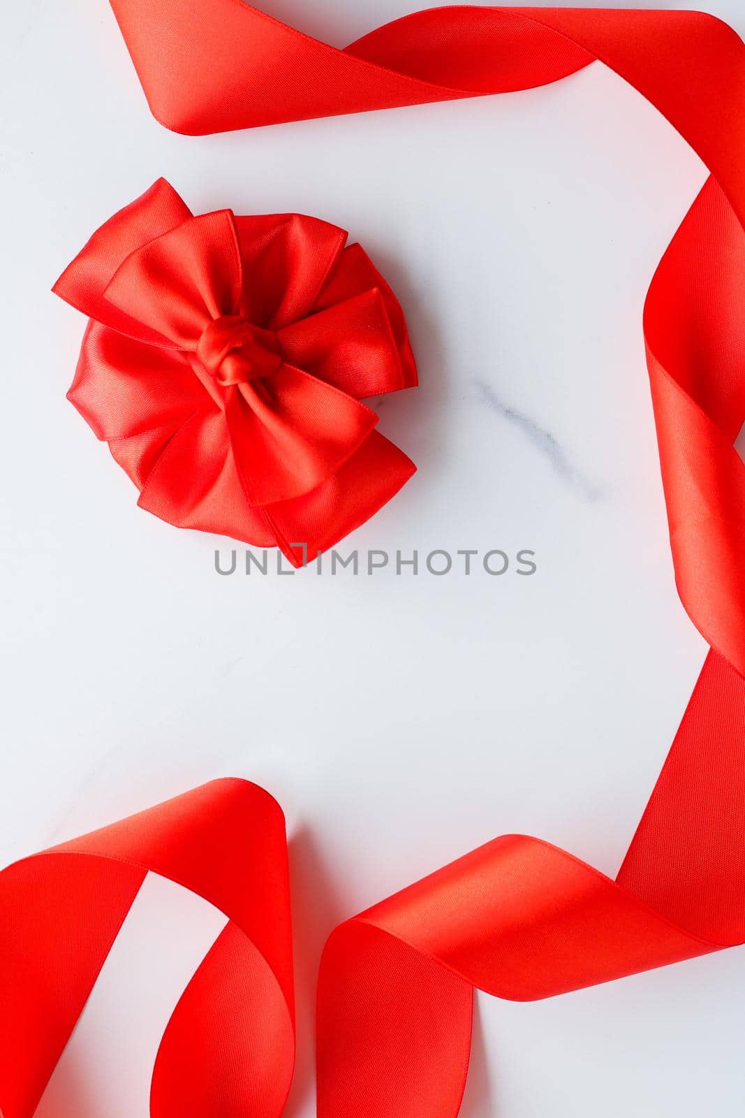 Red silk ribbon on marble, top view by Anneleven